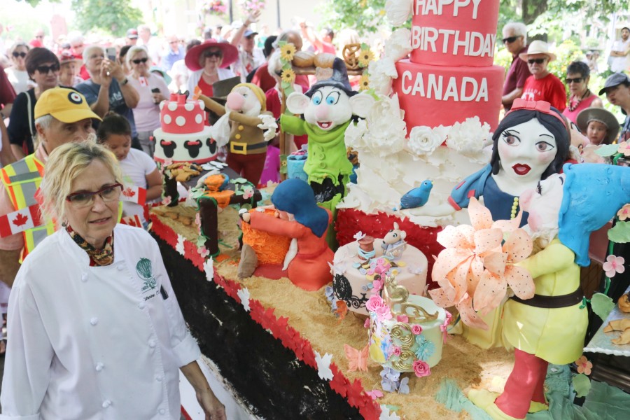Chef Catherine O'Donnell escorts the Canada Day cake to Simcoe Park. (Dariya Baiguzhiyeva/Niagara Now)