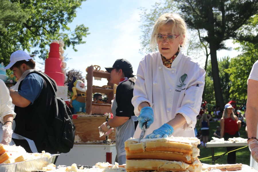 Chef Catherina O'Donnell cuts the slab of the giant Canada Day cake. (Dariya Baiguzhiyeva/Niagara Now)