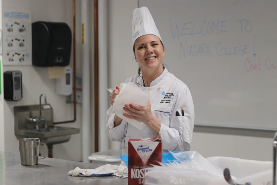 Carol Heafey, chef professor at Niagara College, shows how to make an ice-cream in a bag. (Dariya Baiguzhiyeva/Niagara Now)