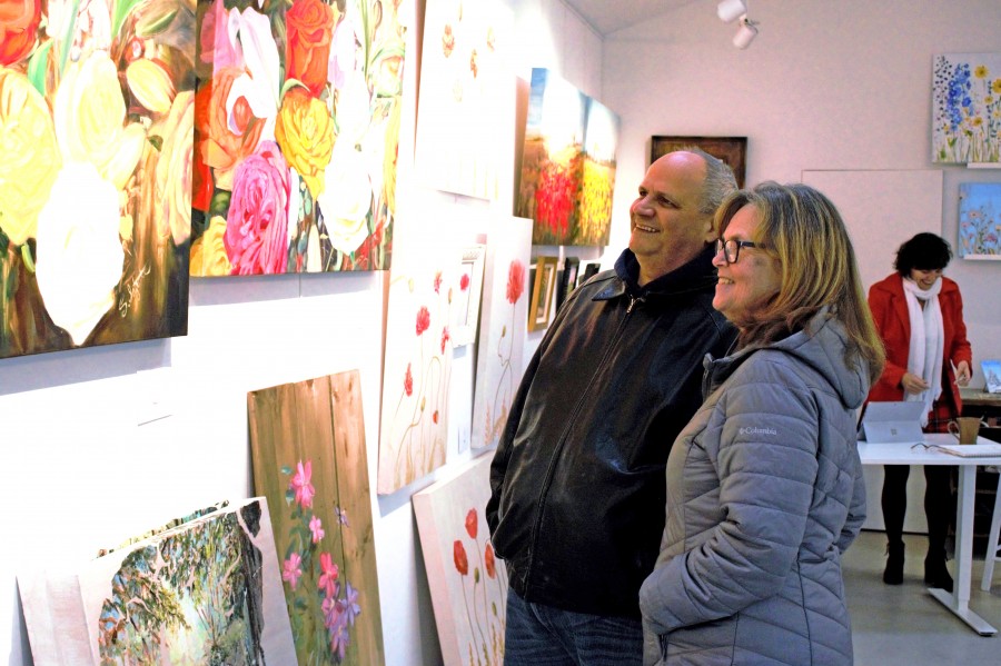 Frank and Michele Guglielmi peruse Sandra Iafrate’s paintings during her Gate Street Studio open house last weekend. (Brittany Carter/Niagara Now)