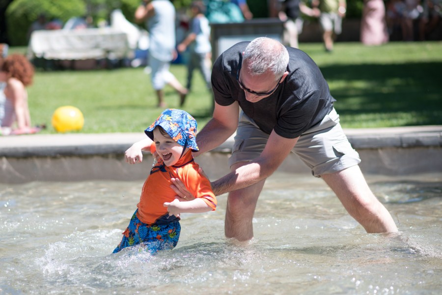 Sean Degroot swings his grandson Elijah Flynn through the wading pool at Simcoe Park. (Eunice Tang/Niagara Now)