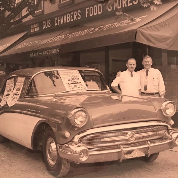 Gus Chambers, left, and an unknown associate in front of the Red & White grocery store. The store is now Nina Gelateria on Queen Street. (Supplied)