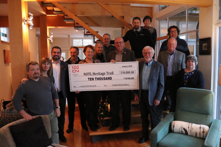 Donors and members of the Heritage Trail Committee celebrate the successful fundraising for the trail's restoration work at a cocktail party held Jan. 8. On behalf of the Canadian National Railway, the company's manager of public affairs Daniel Salvatore (third from left) presented a cheque worth of $10,000 to the committee and the Town of NOTL. (Dariya Baiguzhiyeva/Niagara Now)
