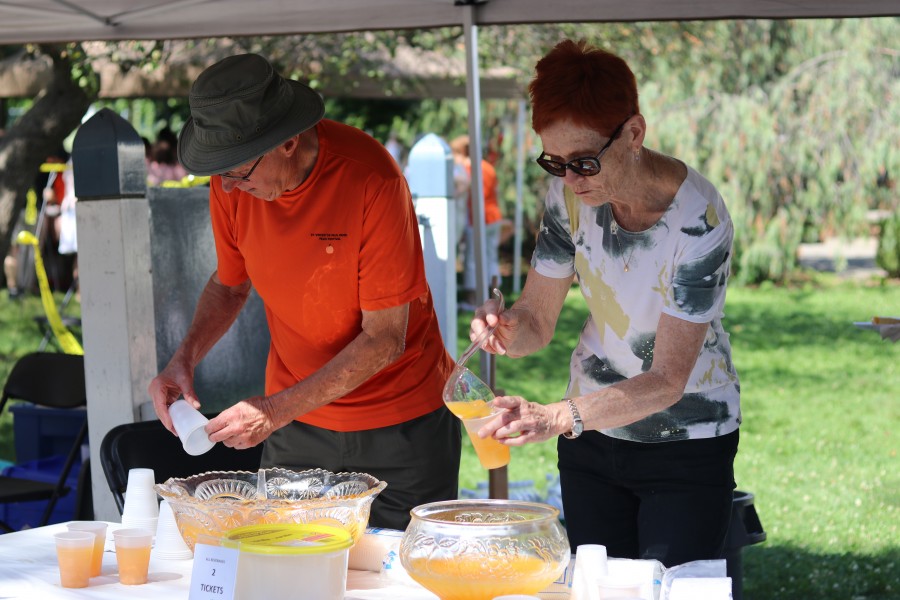 Leon Martin and Virginia Vickers serve peach juice. (Dariya Baiguzhiyeva/Niagara Now)