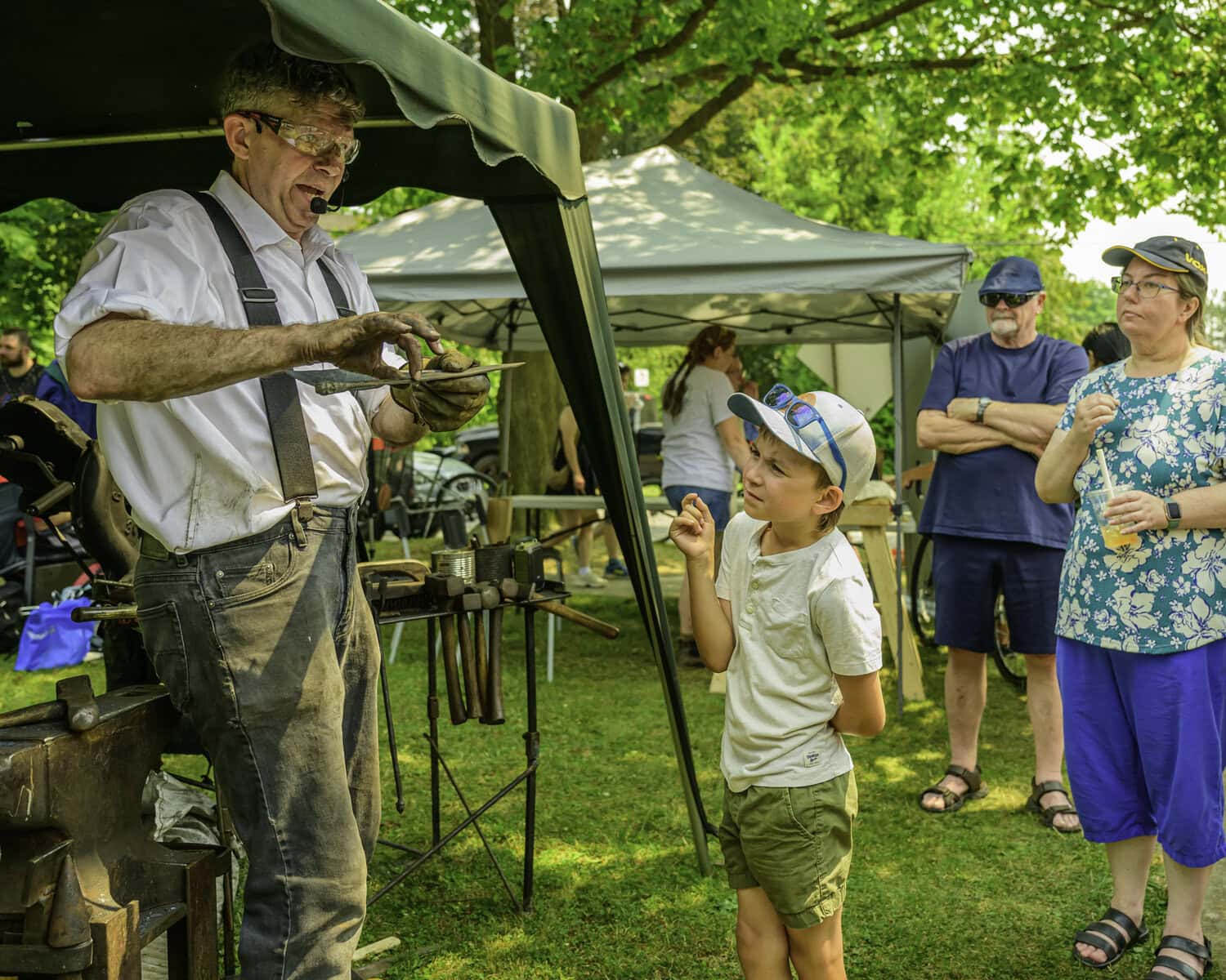 Seven-year-old Trent Colyn watches blacksmith David Brandow of Firesword Forge demonstrate one part of his trade, the history of which goes back millenia.