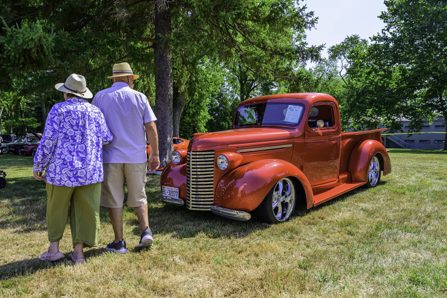 A couple of showgoers eye this hot red 1939 Chevrolet pickup.