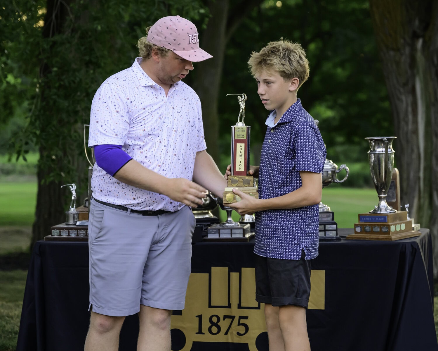 Club pro Owen Howells presents the bantam boys trophy to winner Steven Pillitteri-Smith.