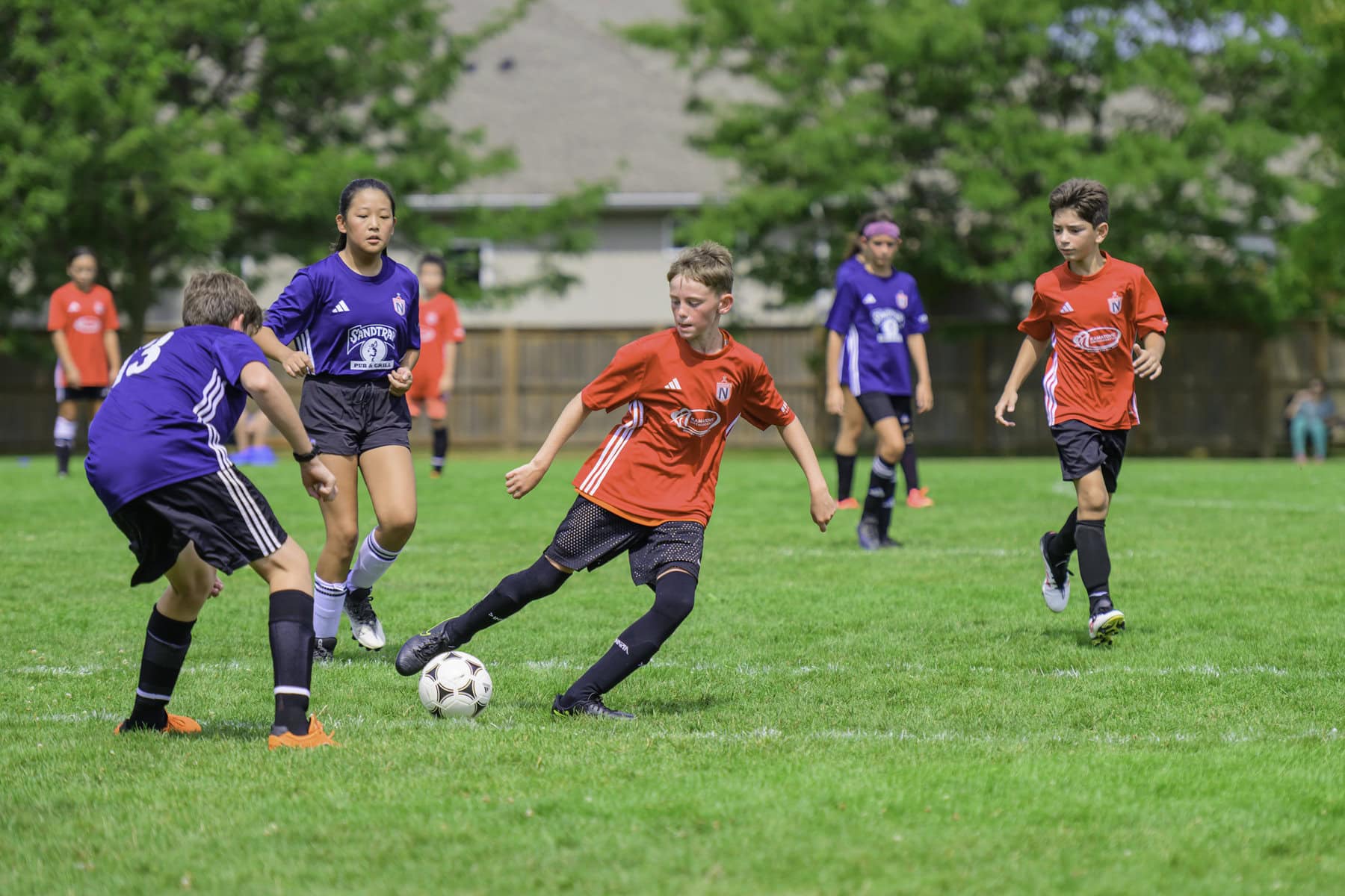 Playing in the U-12 league, Matthew Kroker of the Kamatrics Orthodontic team gets the ball and goes against the Sandtrap Pub and Grill team.
