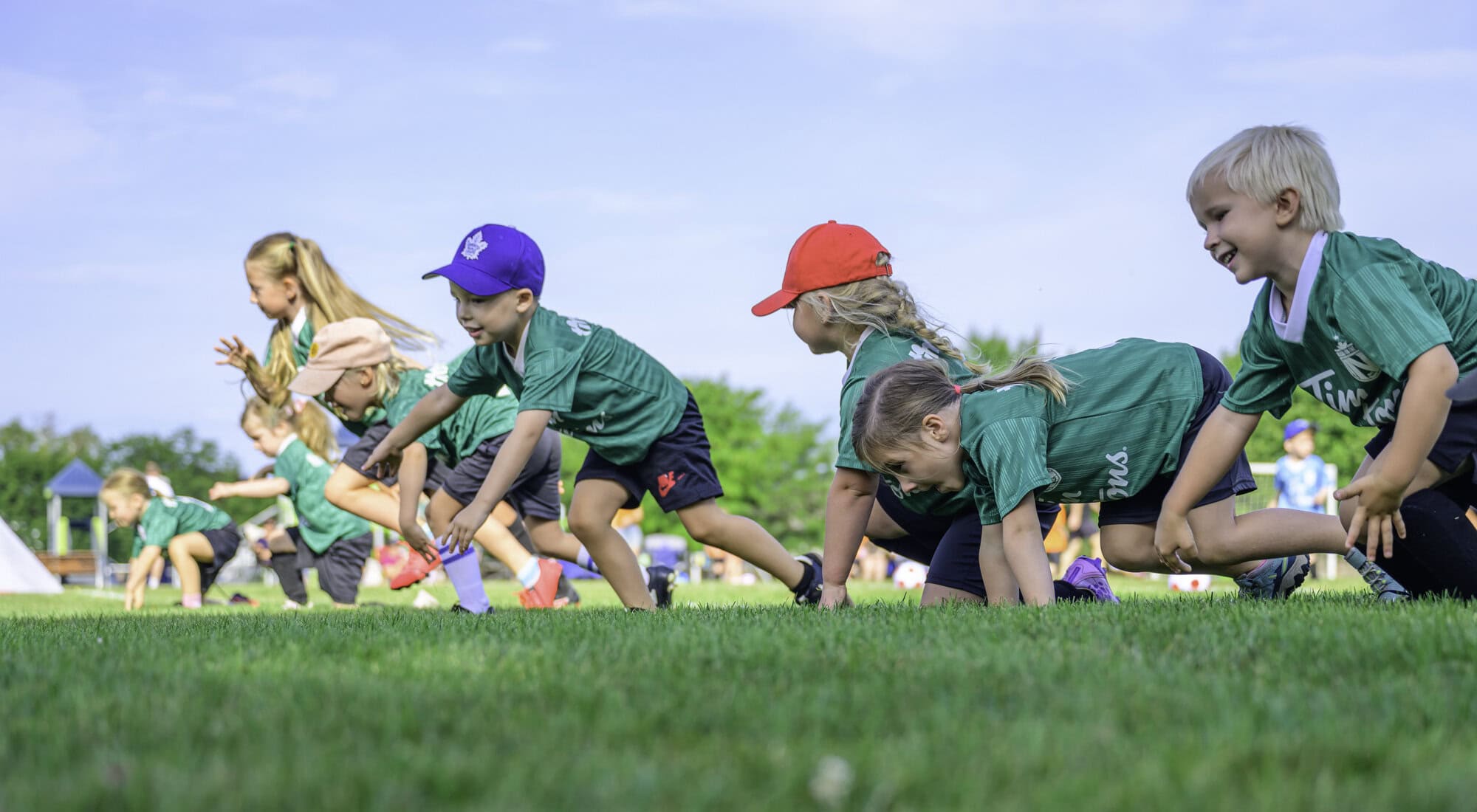 Among some of the youngest players in the club, the Timbits green team warms up with some practice drills on the field.