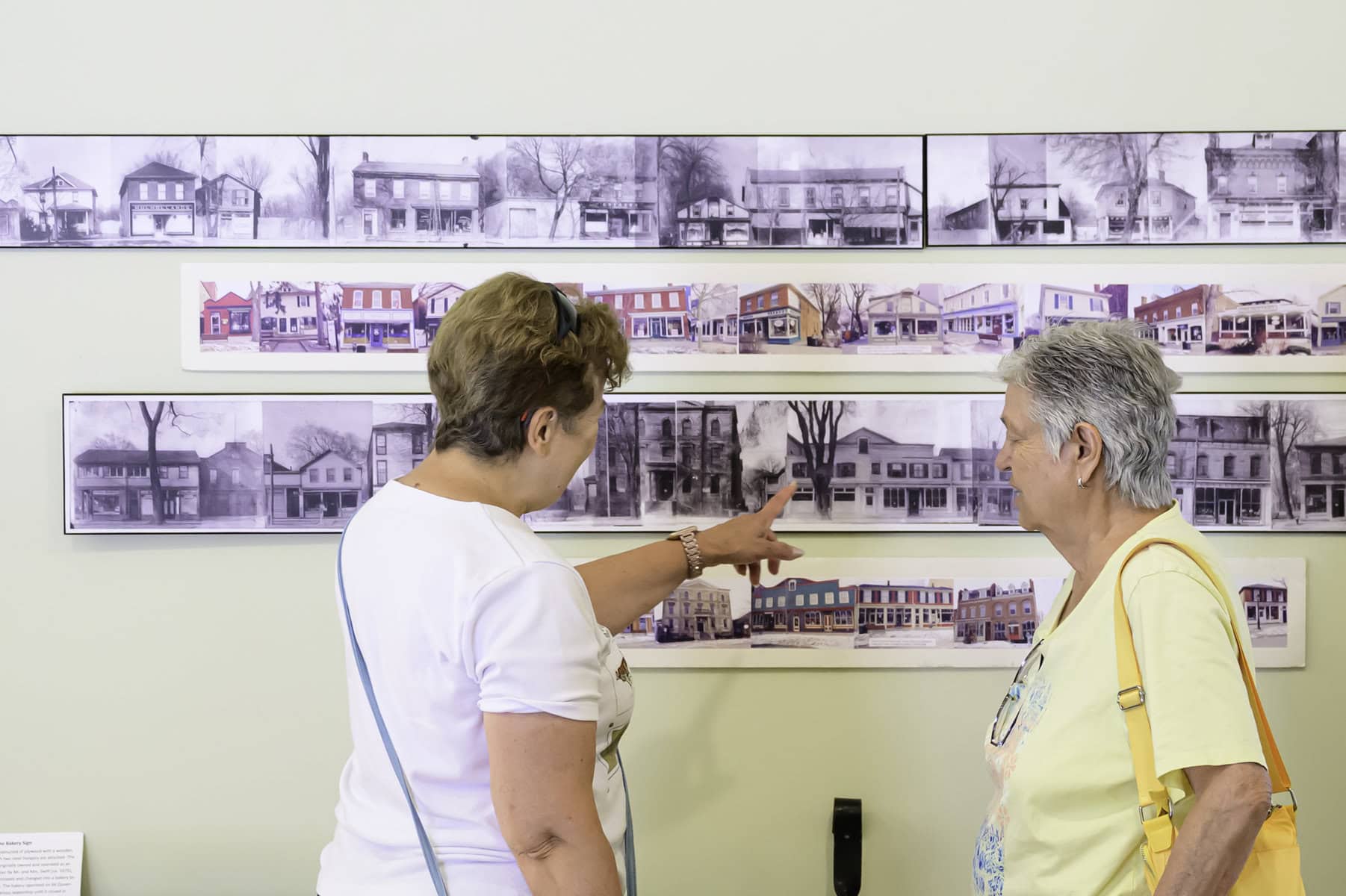 Inside the museum, Elana Bonner shows historical photos to Sharon Becker.