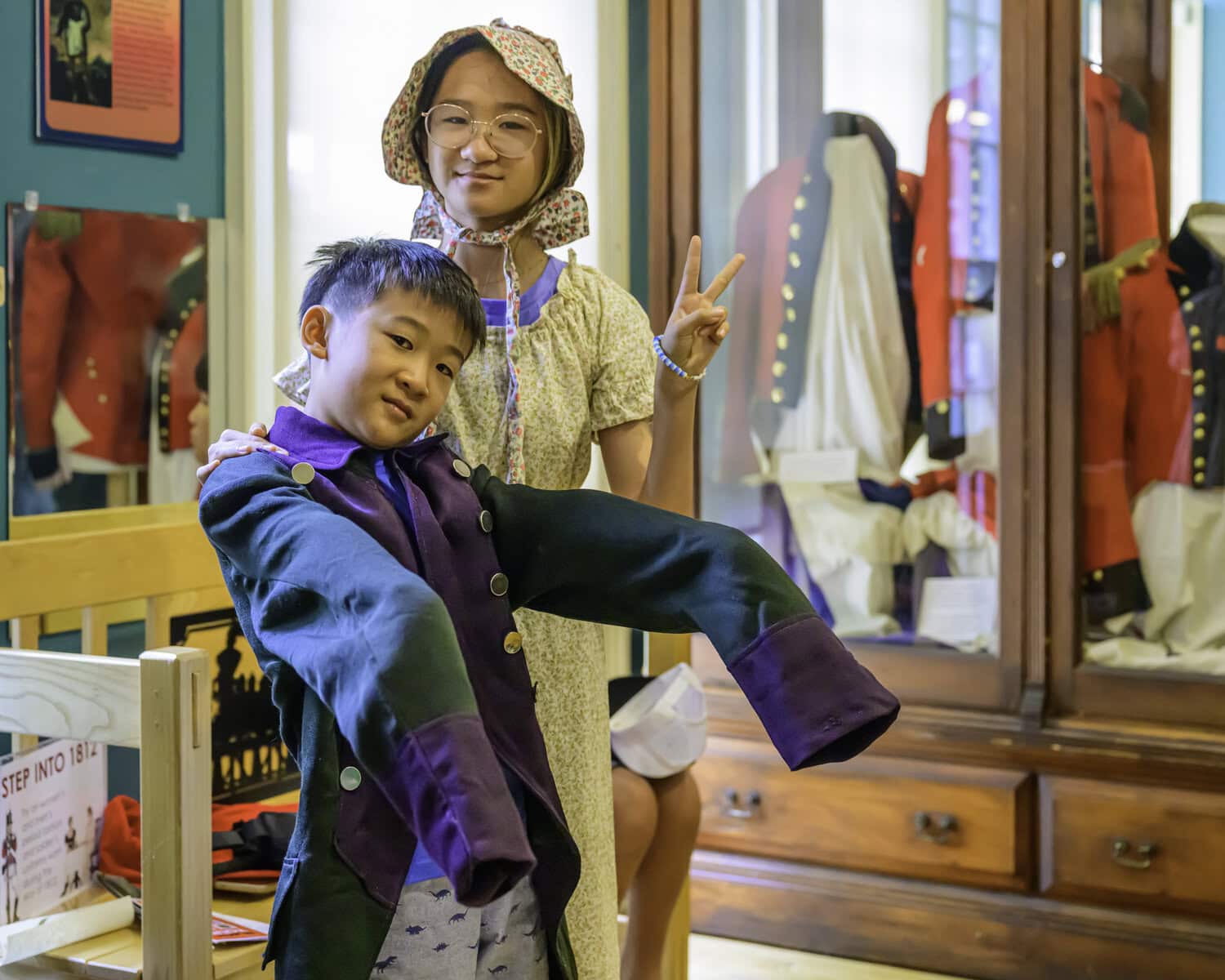 Daniel Chiel, 9, might need a trip to the tailor's before he can rock this historical coat he tried on inside the museum. Behind him is 13-year-old Miriam Chiel.