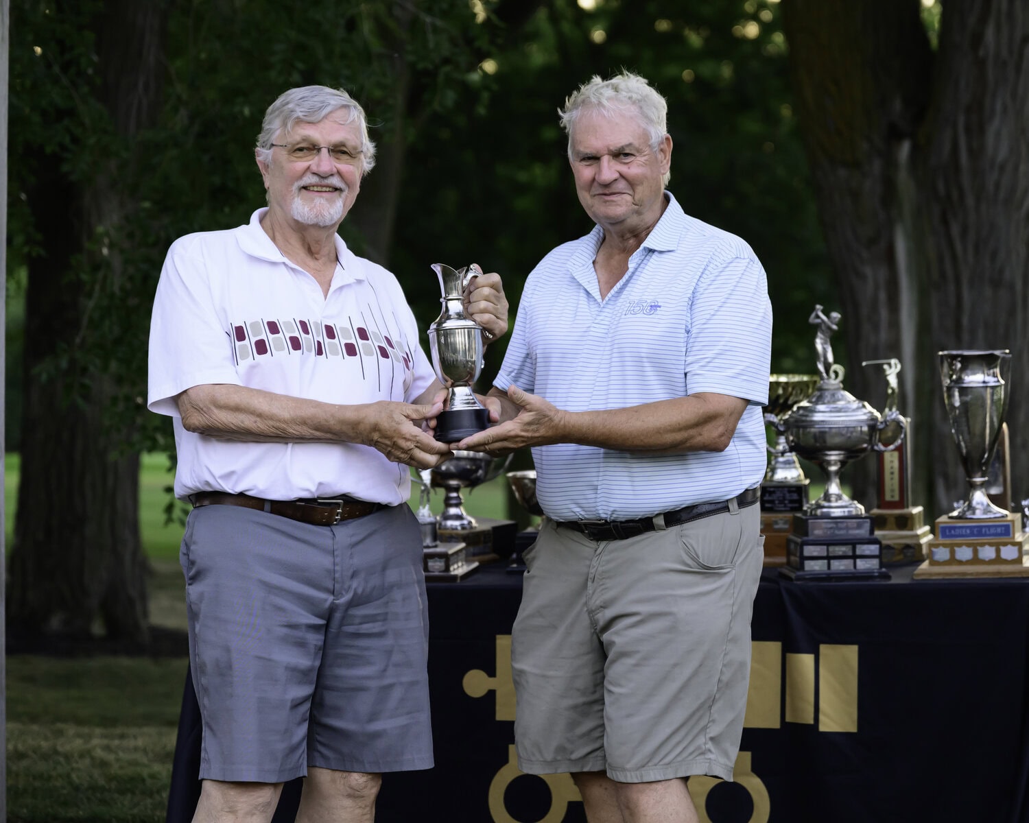 Rai Lauge receives the Legends Cup from Don Cruikshank, one of the organizers of the annual competition for men over 80.
