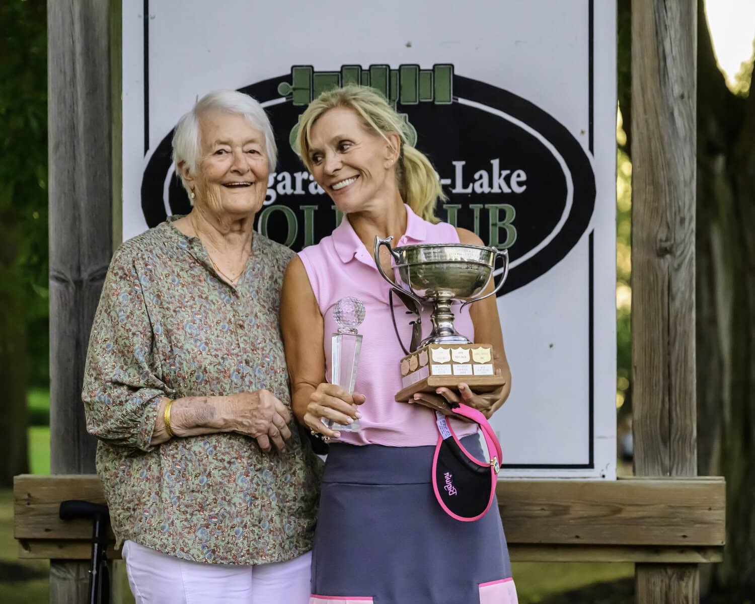 Retired longtime club member Barbara Ahluwalia congratulates women's champion Louise Robitaille.