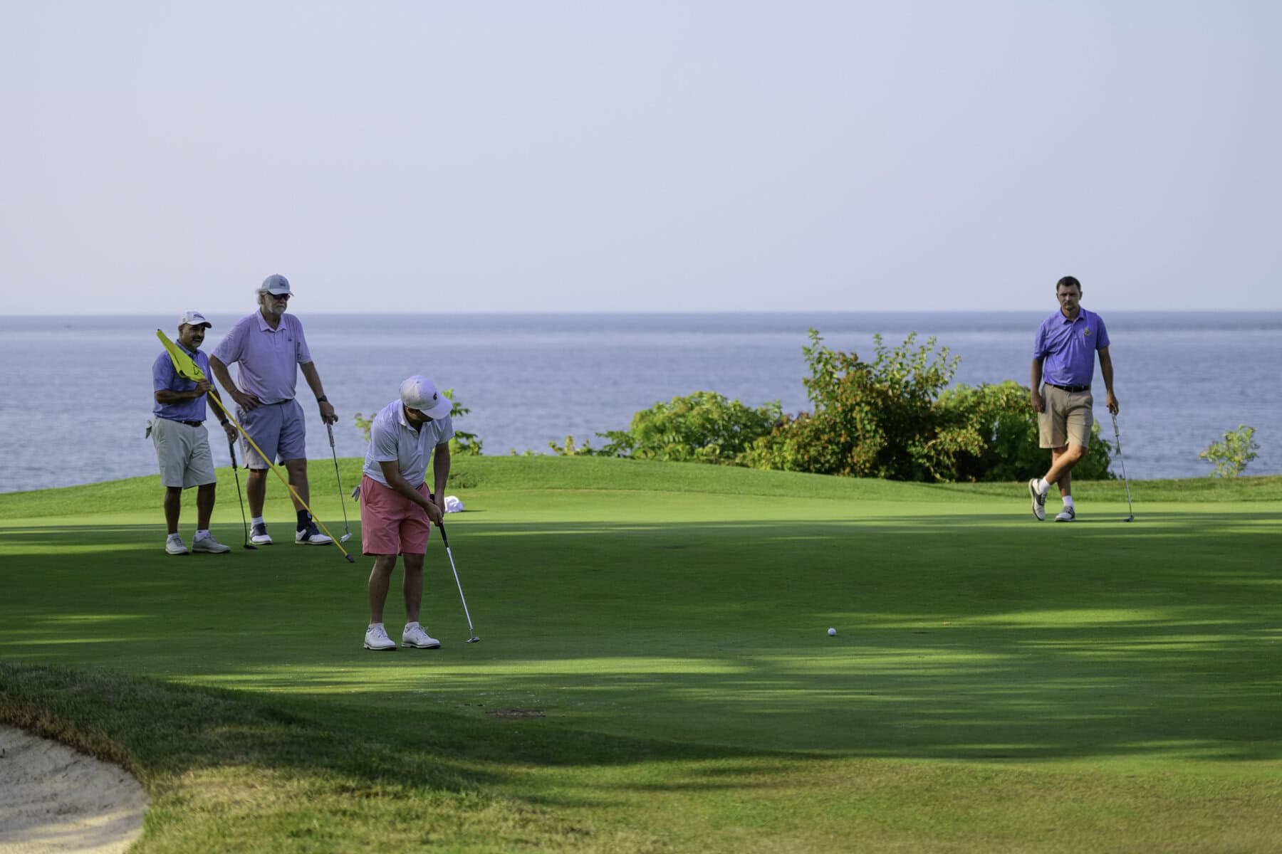 Ricky Watson putts on the sixth hole, as Joe Doria, Stephen Warboys and James Grigjanis-Meusel wait.