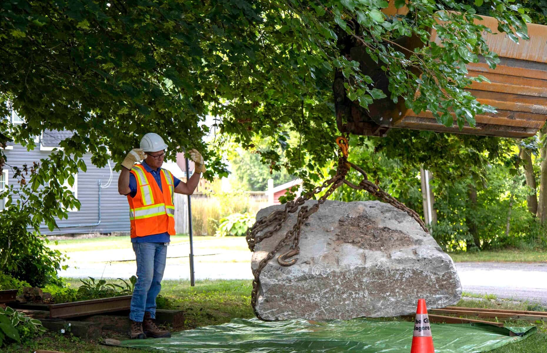 Town supervisor of roads Casey Sharpe helps guide the placement of a newly donated block of Queenston limestone at the turntable site.
