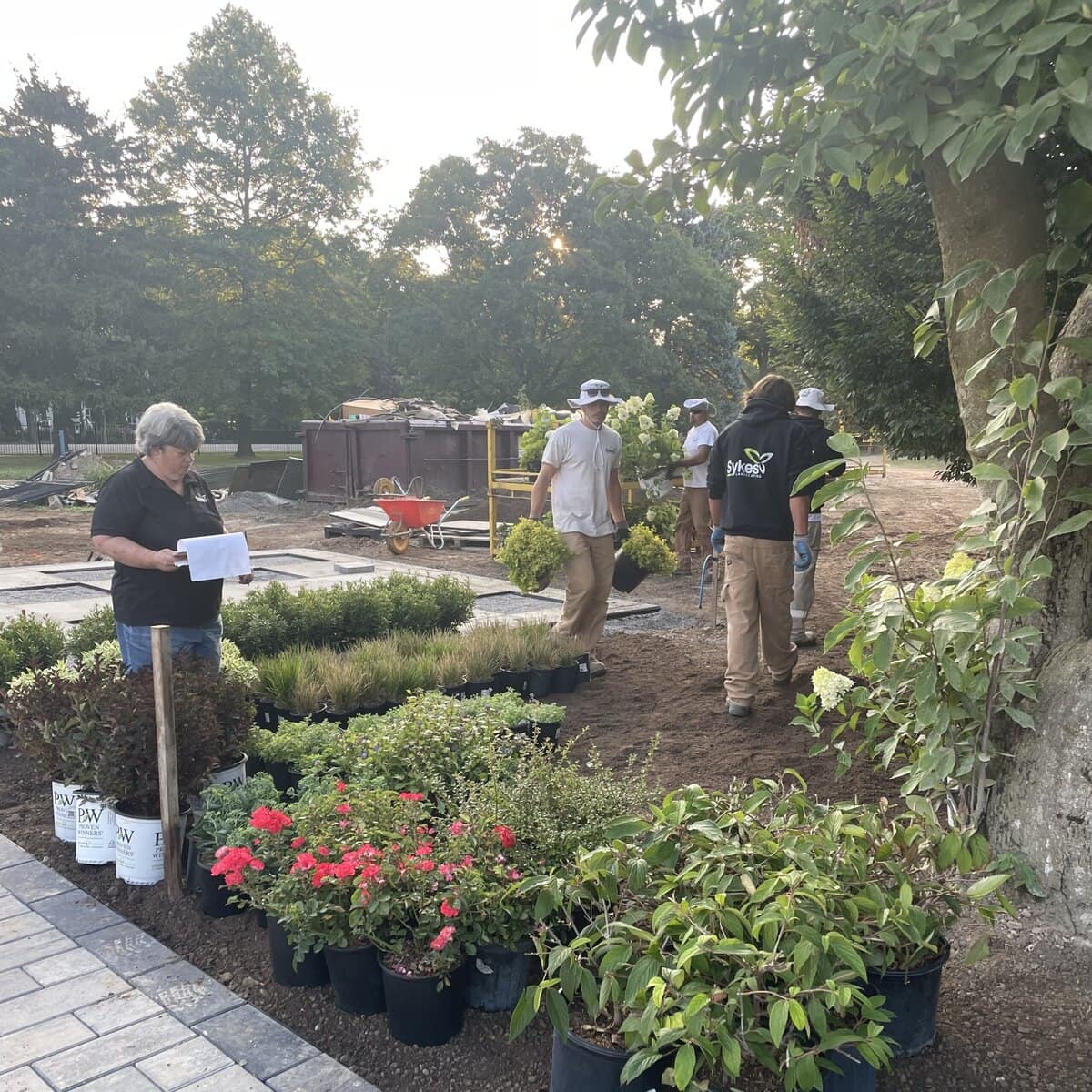 A picture of Joanne Young, left, working with Sykes Landscaping staff on a project. From left, Braeden Bell, Julio Viveros Hernandez, Edan Morris and Steven Novak. 