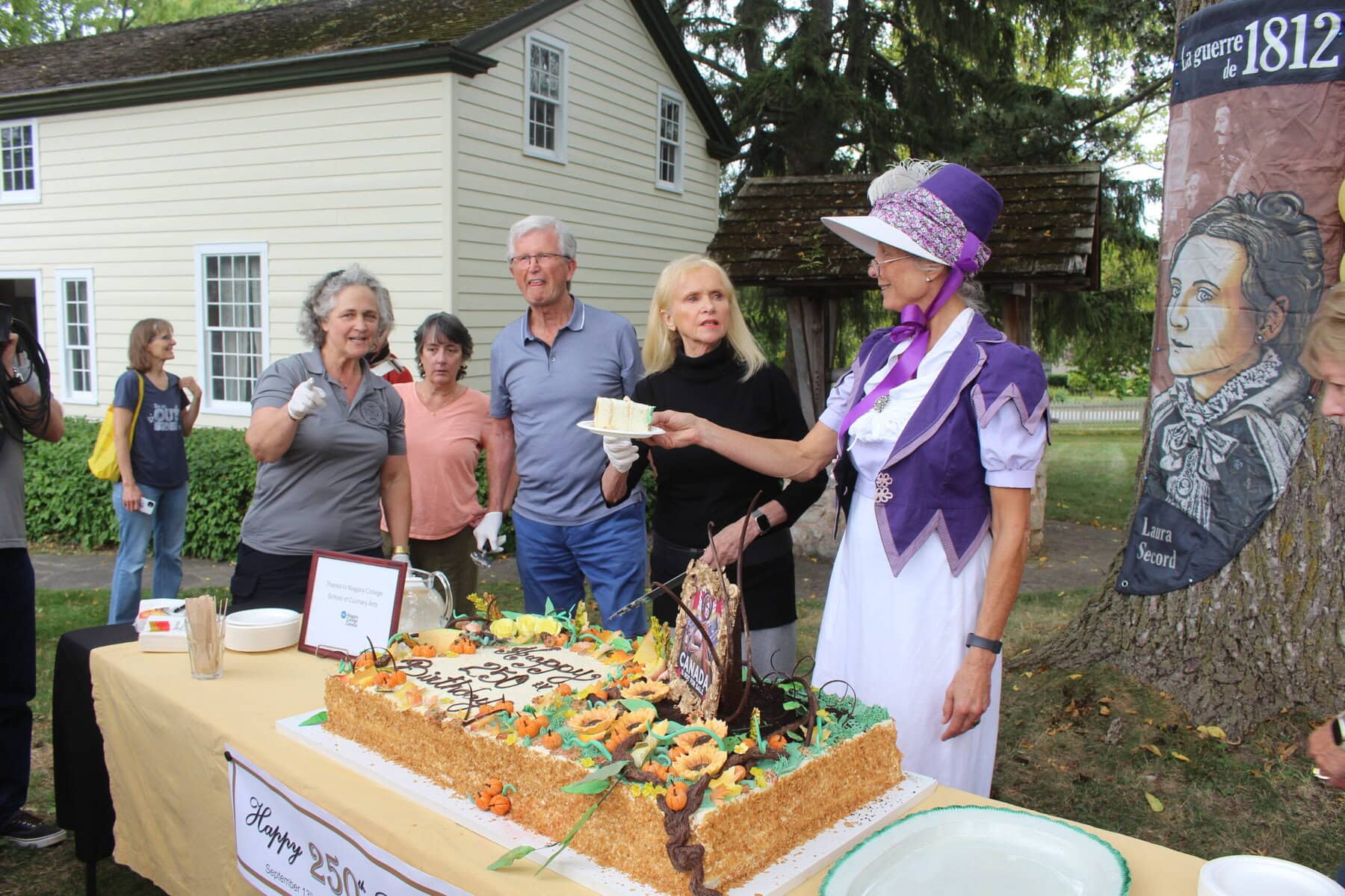 Cathy Thomas serves the first slice of Laura Secord's 250th birthday cake.