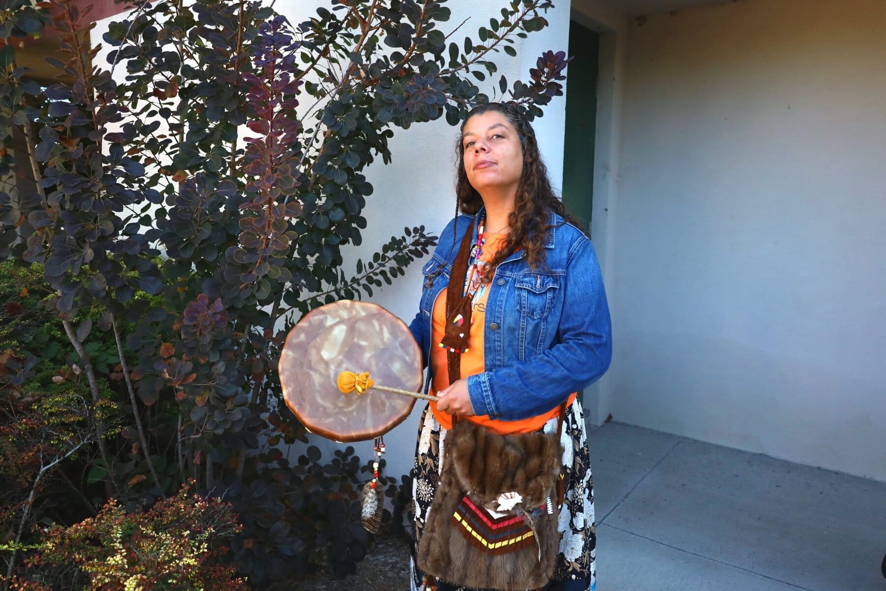Cara-anne Farrow-lawrence demonstrates her drum, featuring great horned owl feathers and beads.