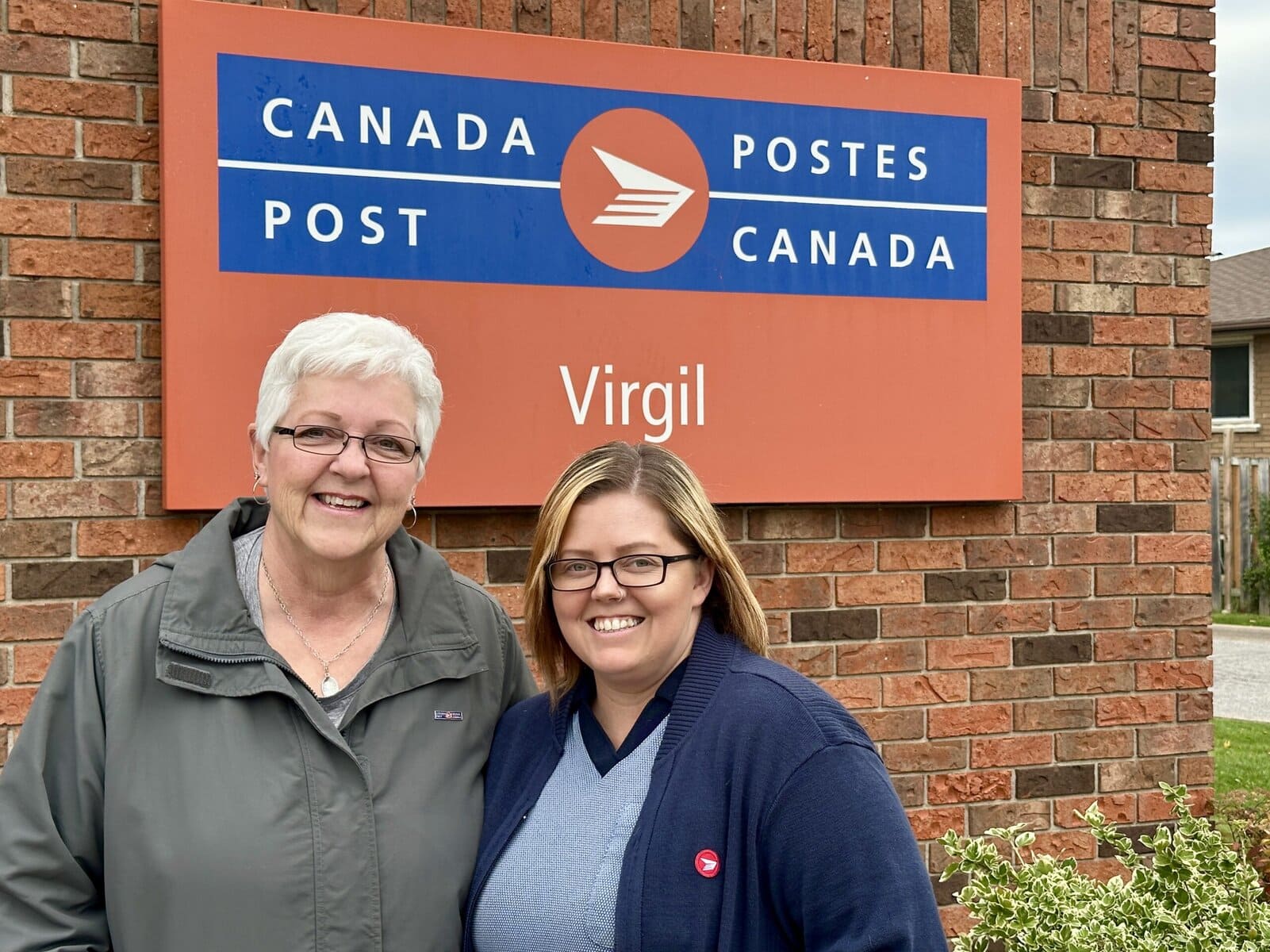 Postmaster Cindy Andrews Friesen, right, stands with longtime colleague and friend Brenda Ferguson, assistant to the postmaster, in front of the Virgil Canada Post office. The two have worked side by side since 2017.