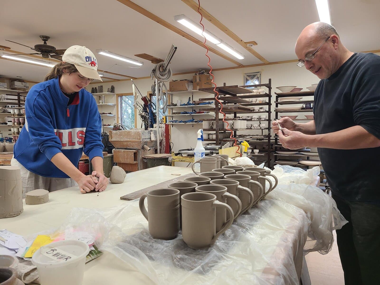 Candace Boese and Rick Mlcak work on mugs during the live pottery demonstration Sunday afternoon. 