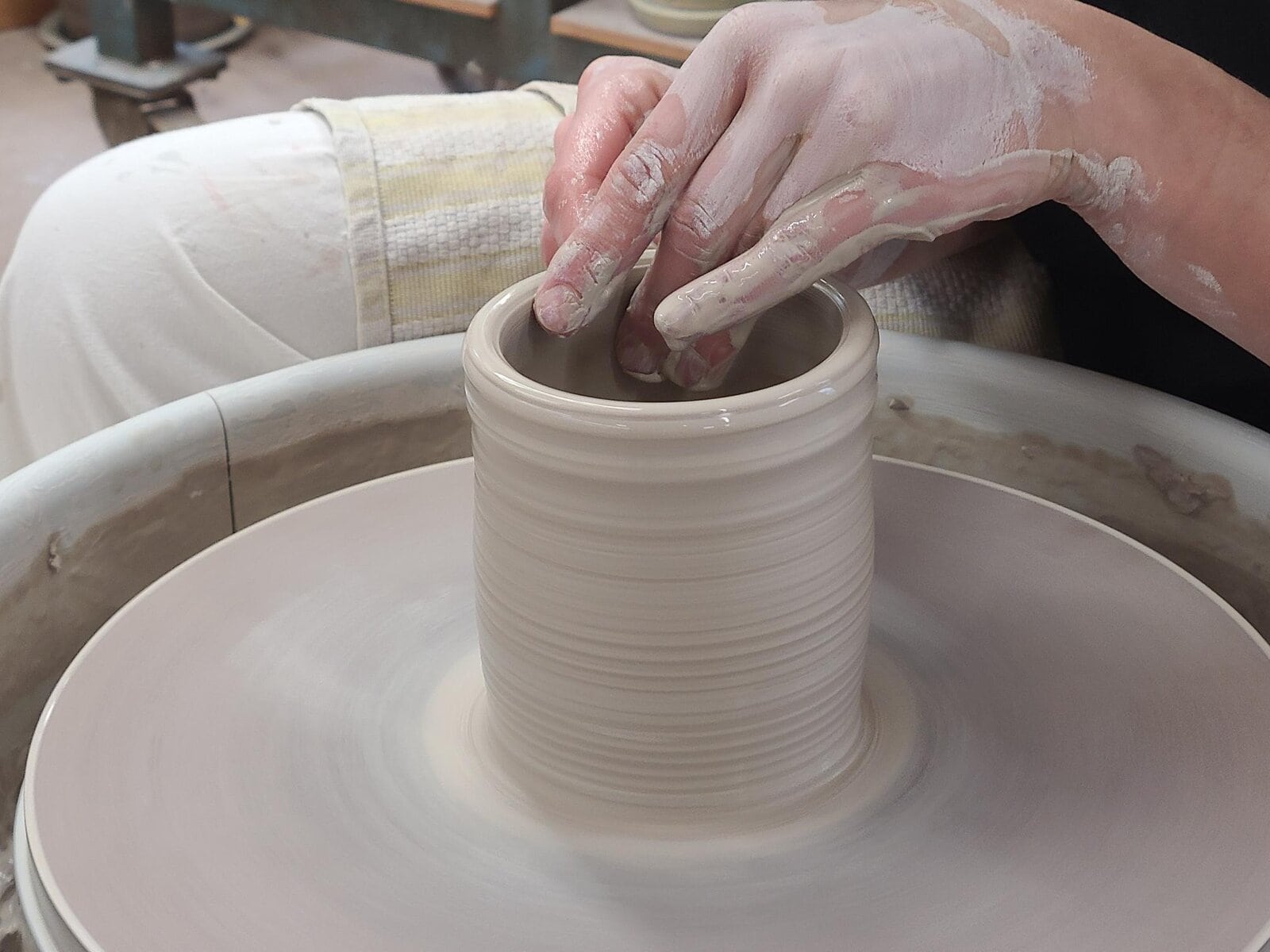 Candace Boese shapes clay on the wheel, showing visitors how a simple form begins to take structure. 