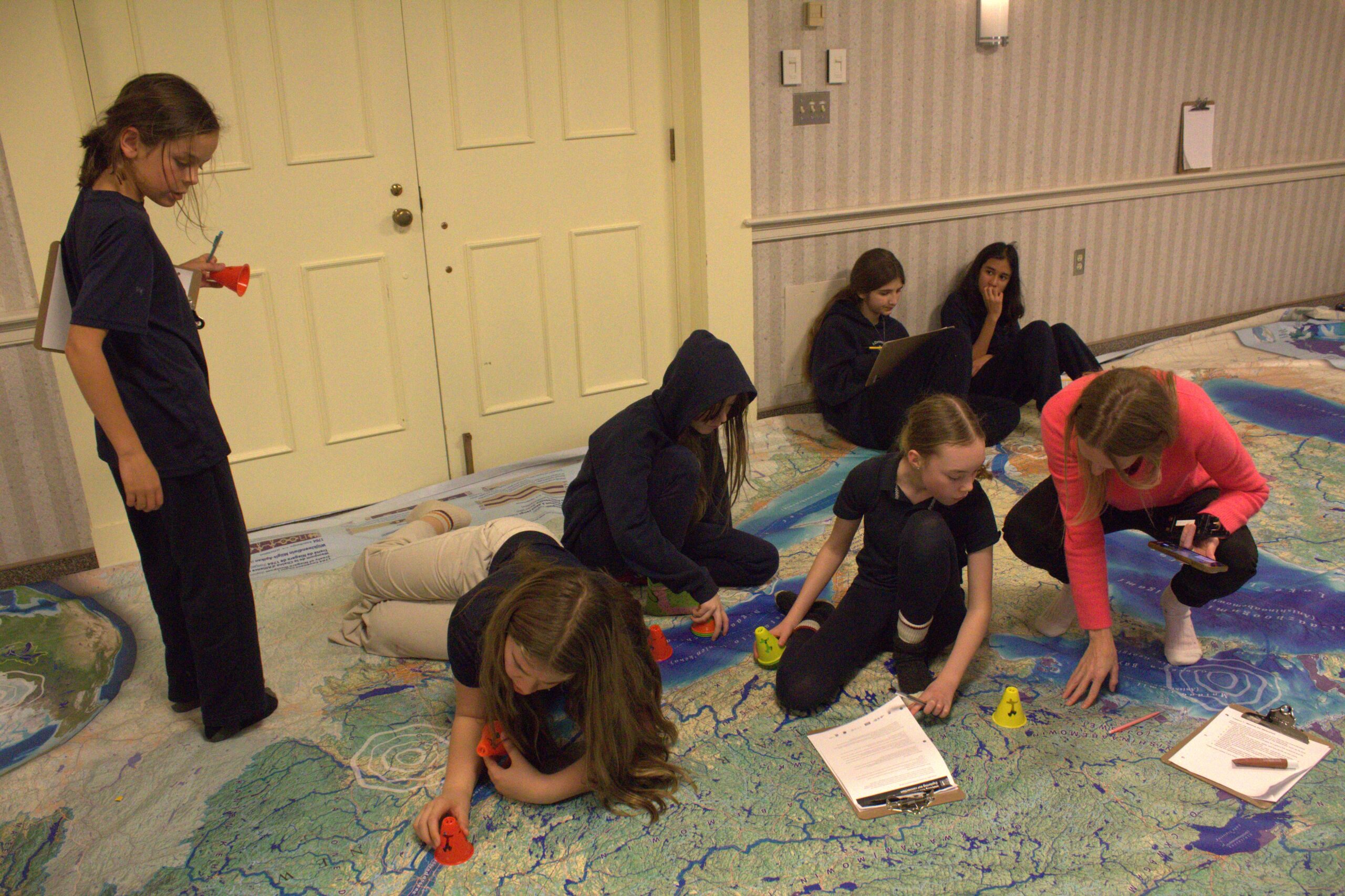 Royal Oak School principal Julia Murray showing her students about the Great Lakes region they live in on the Biinaagami map they received from Canadian Geographic.
