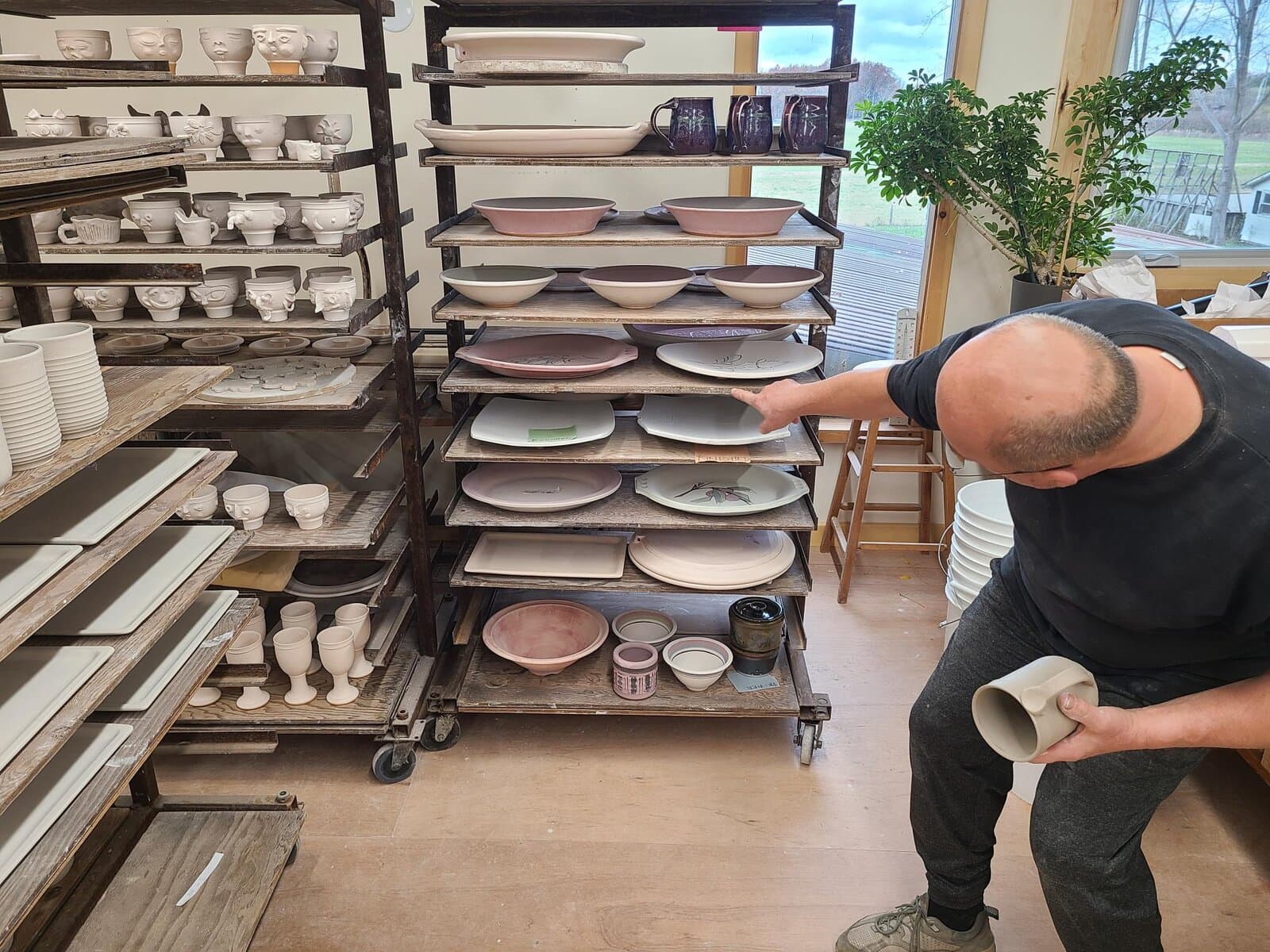 Rick Mlcak points out freshly made platters crafted by students during recent workshops. 