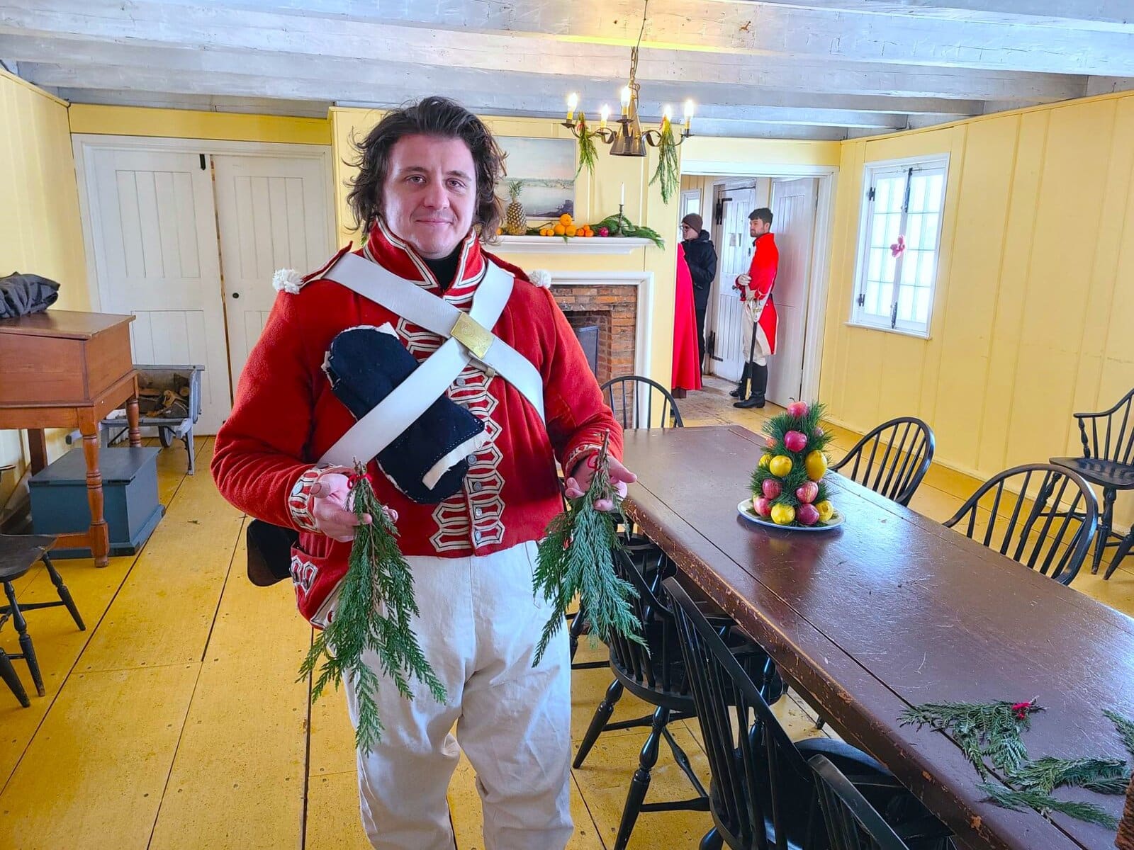 Sam Challen, interpretation coordinator at Fort George, holds bundles of evergreen boughs used in period Christmas decorations.