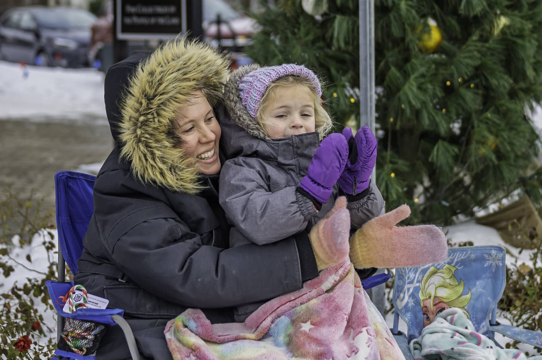 Janine Doiron and her four-year-old, Addy, clap and cheer as the parade goes by.