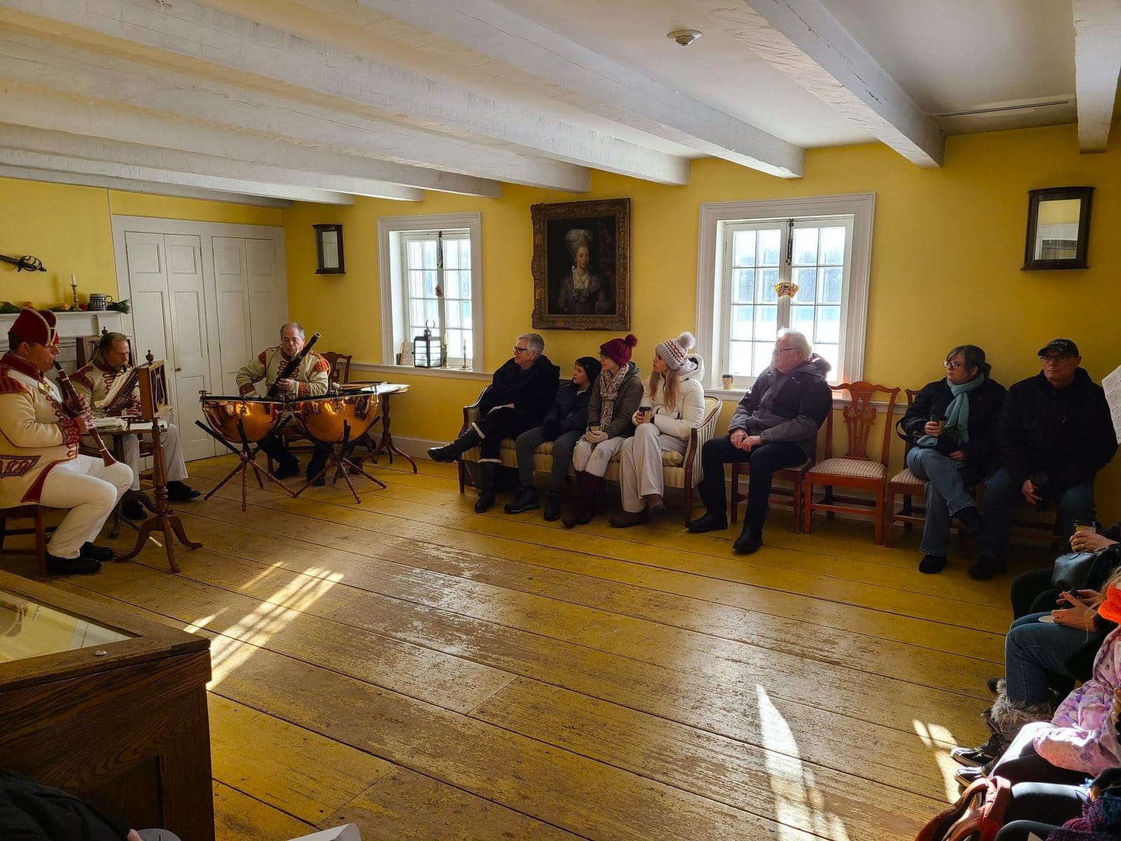 Visitors listen as the 41st Regiment Band of Music performs inside one of Fort George’s historic buildings, the Officers' Quarters, during Garrison Christmas. 