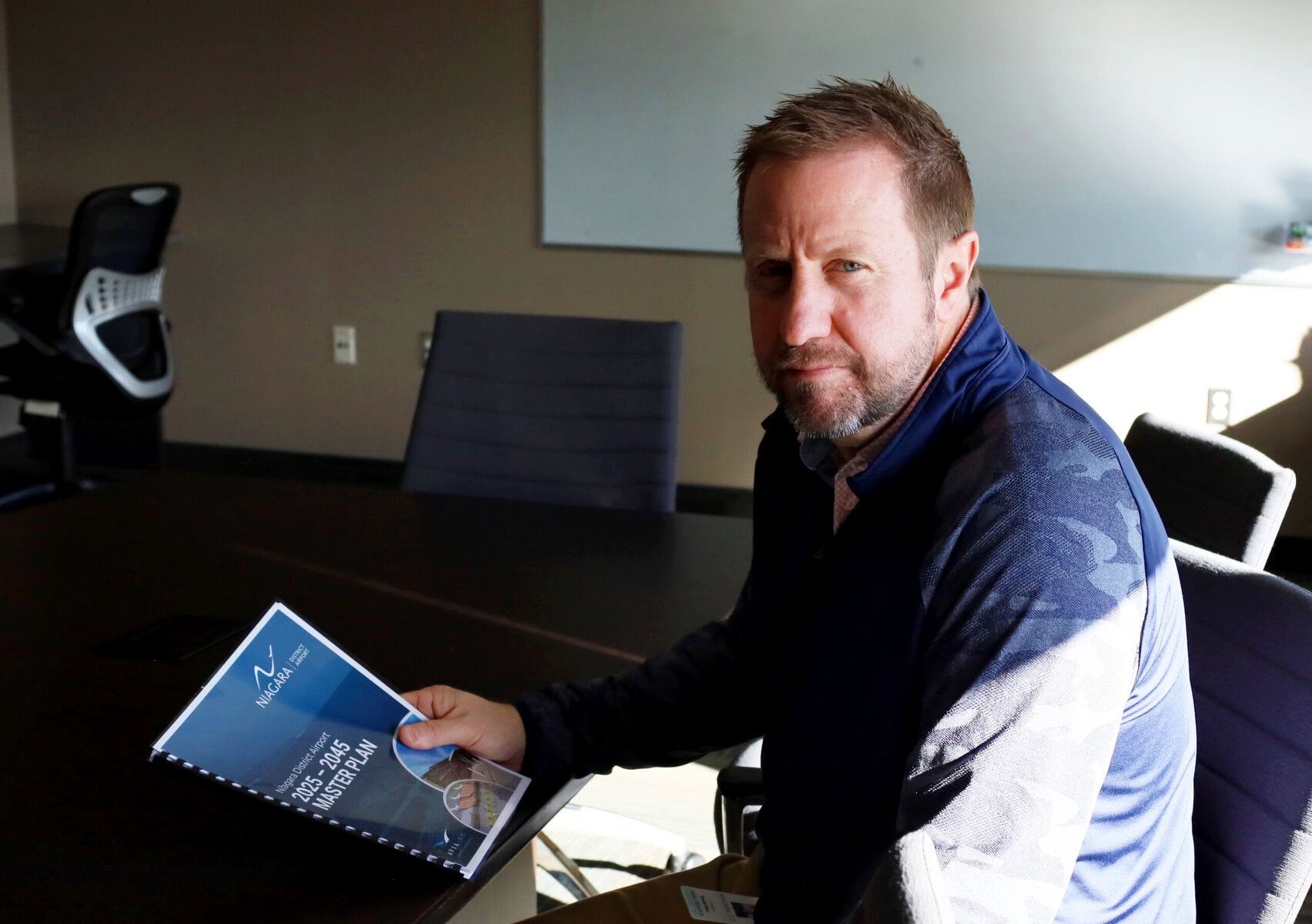 Flights from NOTL to cities like Ottawa or Chicago could one day take off under a newly approved $195-million, 20-year master plan to expand and modernize the Niagara District Airport. Here, airport CEO Dan Pilon holds in his hands the final copy of the master plan, published in November. 