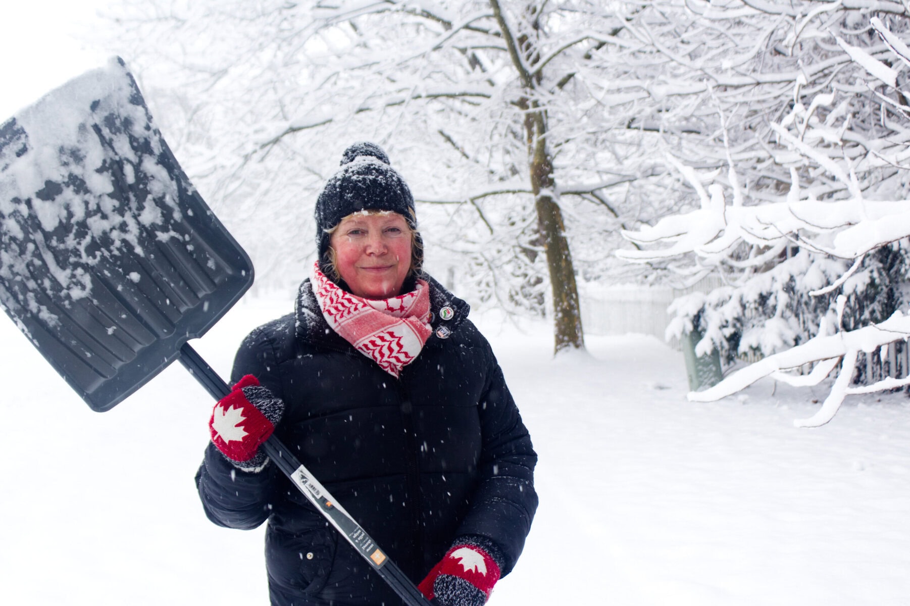 Lauren O'Malley shovels snow on Mississagua Street on Thursday, clearing a pathway during a snow storm on Thursday that dropped 15 to 25 centimetres on the town.