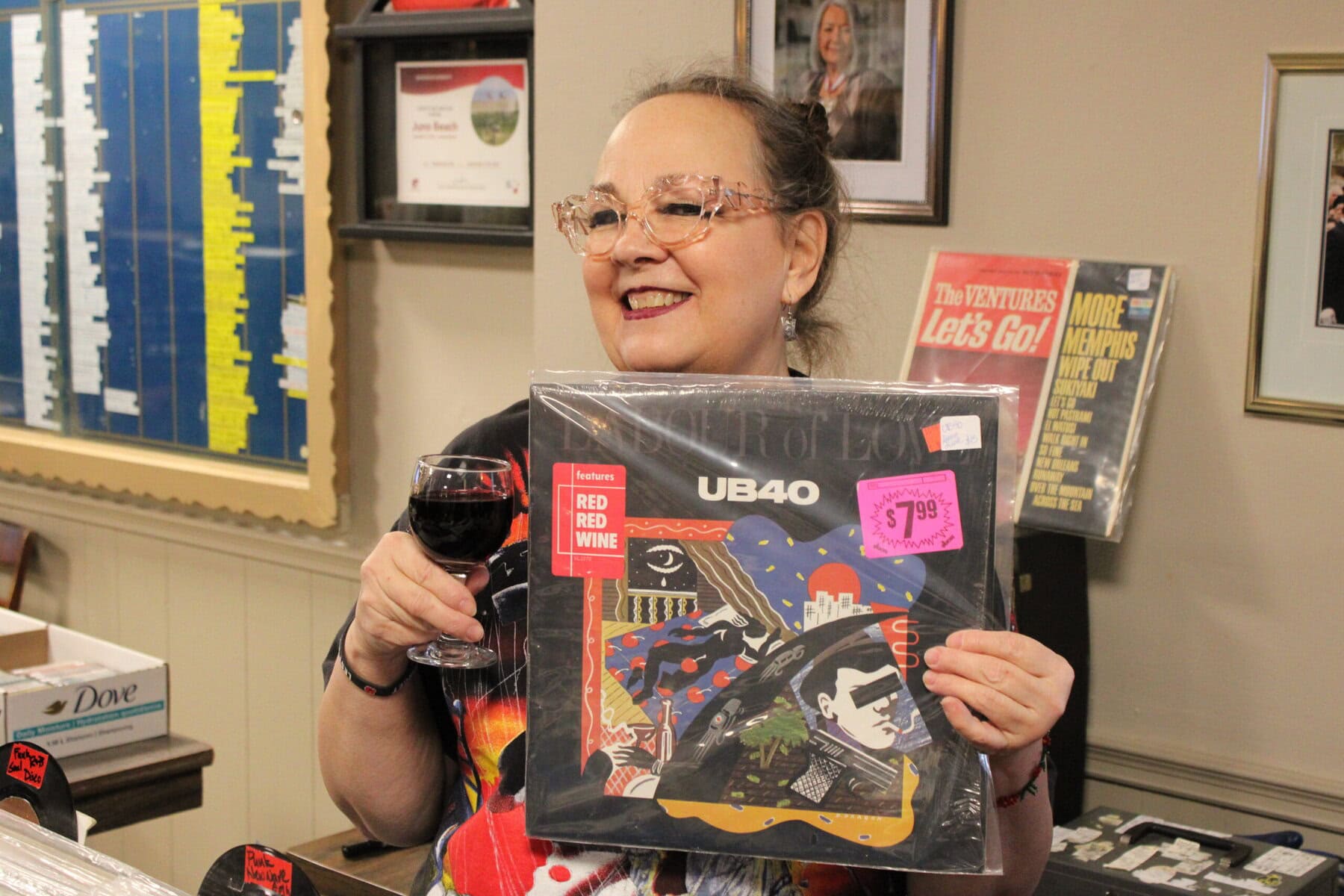 Legion board member Chrystal Haverstock with one of her favourite records, "Labour of Love" by British reggae band UB40, featuring their hit single, "Red Red Wine" — and an appropriate drink pairing — at the Branch 124 Record Show on Sunday.