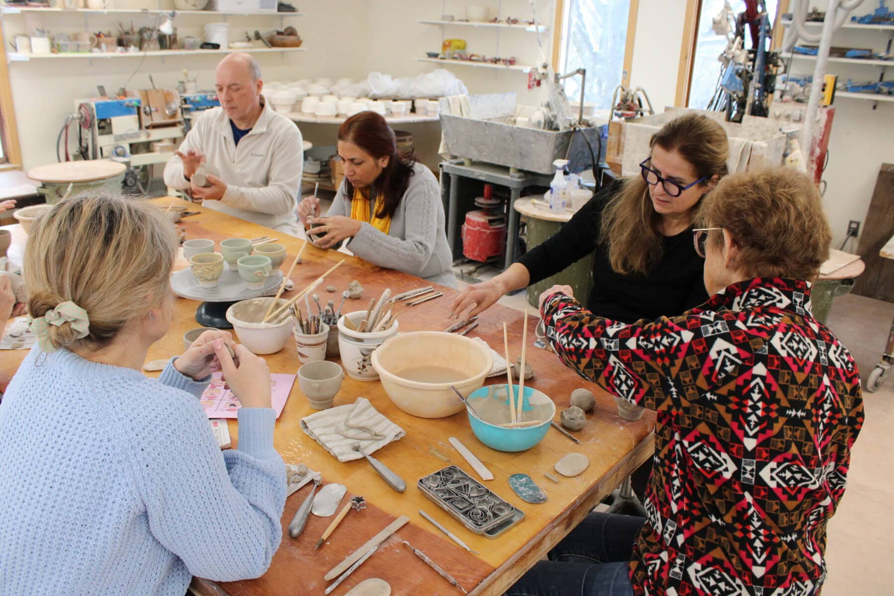 People hard at work crafting their own face cups at the Sunday workshop at Queenston Pottery.