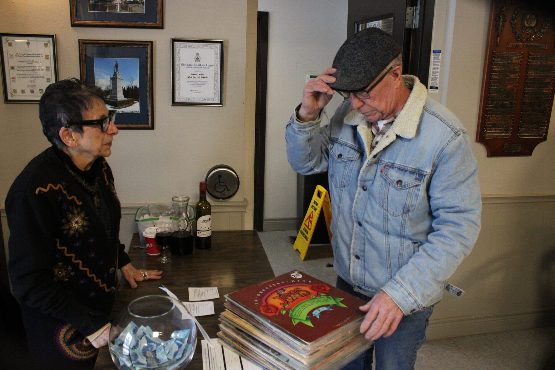 Volunteer Genevieve Habib talks to Kevin Hooper who purchased more than 30 records at the Branch 124 Record Show on Sunday.