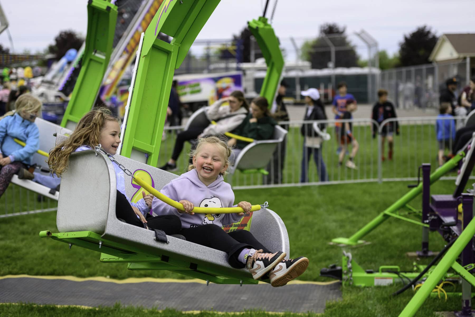 Six-year-old Violet Miles and four-year-old Lake van de Laar have a whirlin' good time on the swings at the Virgil Stampede on May 18, which raised more than $100,000 for the community.
