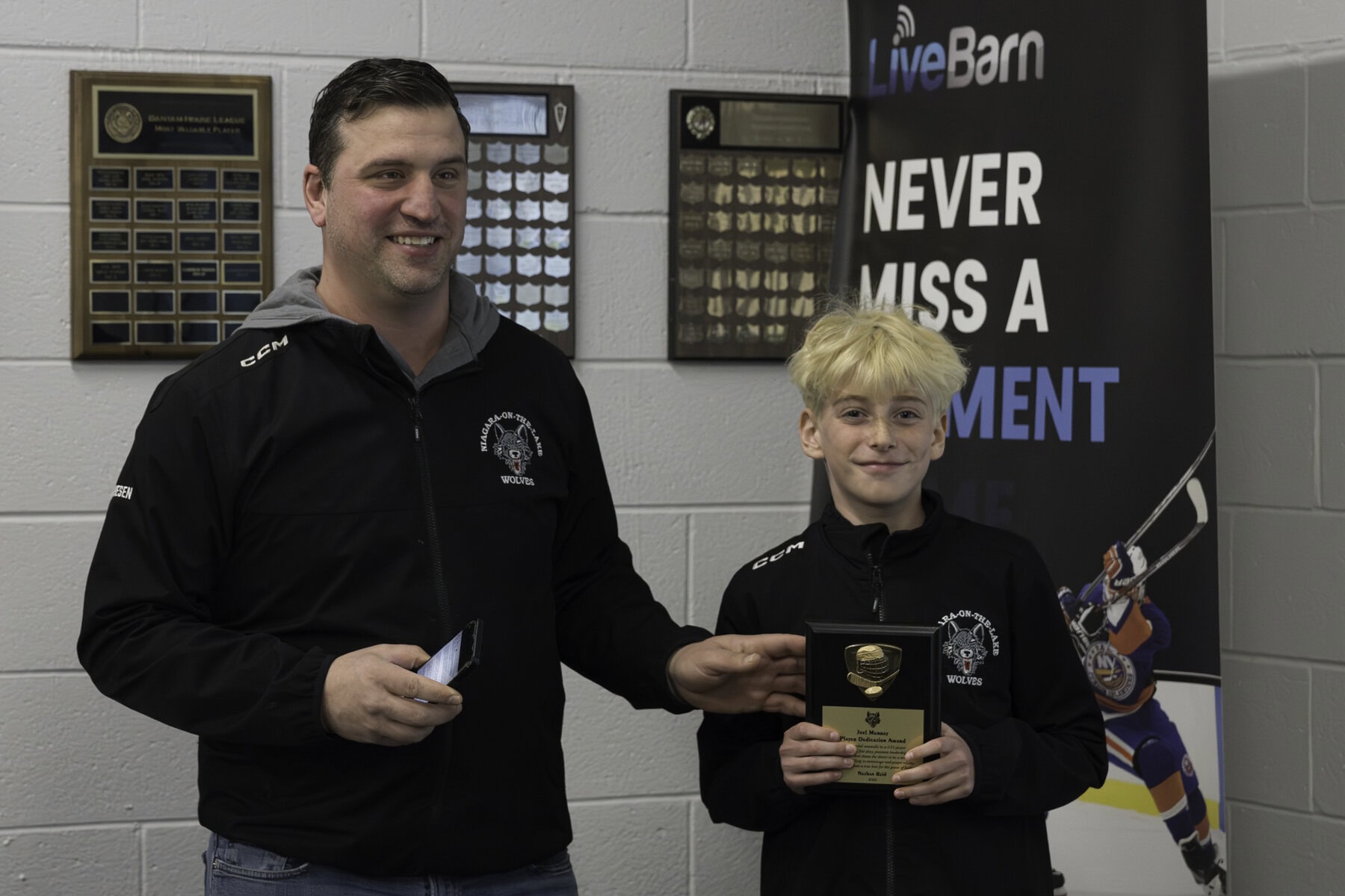 Association vice-president Gary Friesen presents the Joel Murray Player Dedication Award to Nathan Reid. 