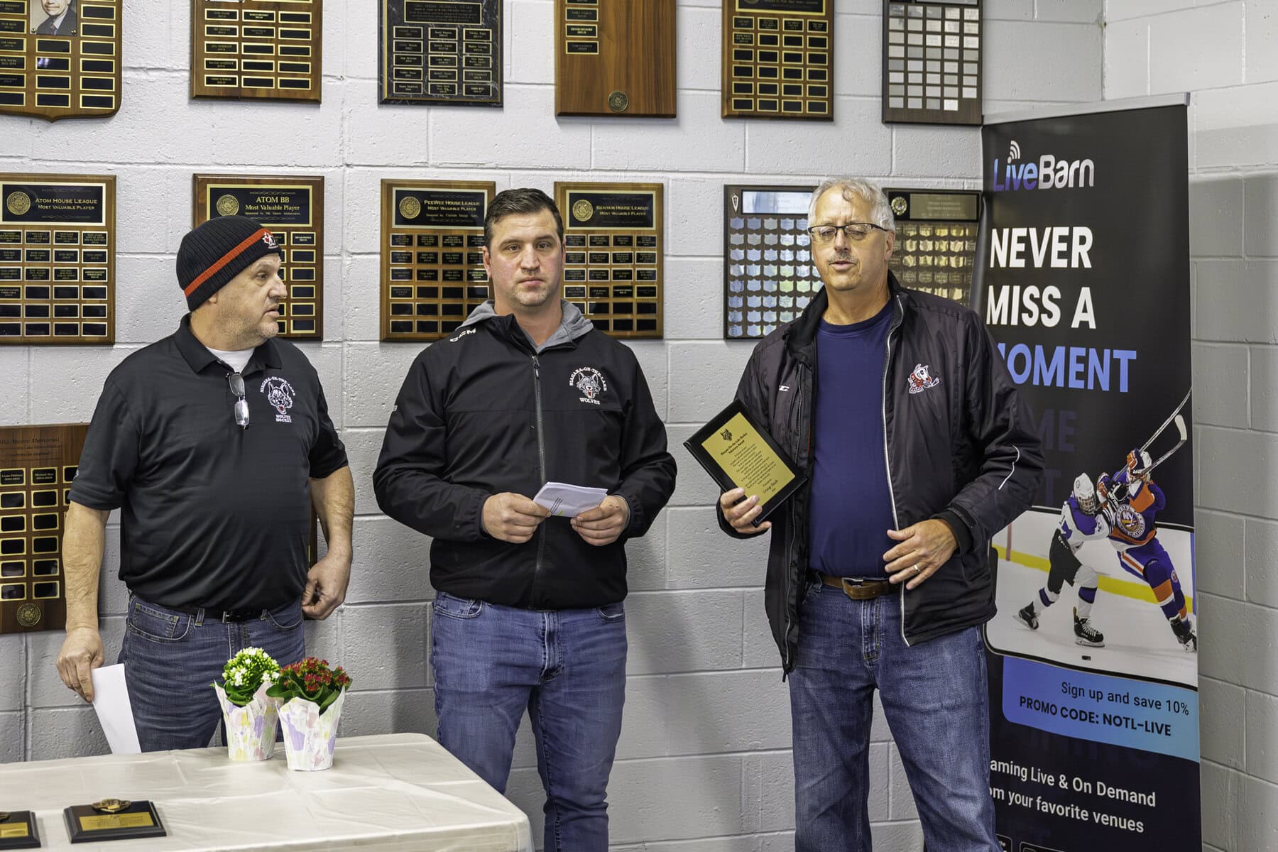 NOTL Minor Hockey president Peter Flynn and vice-president Gary Friesen congratulate Volunteer of the Year award winner Craig Slack.
