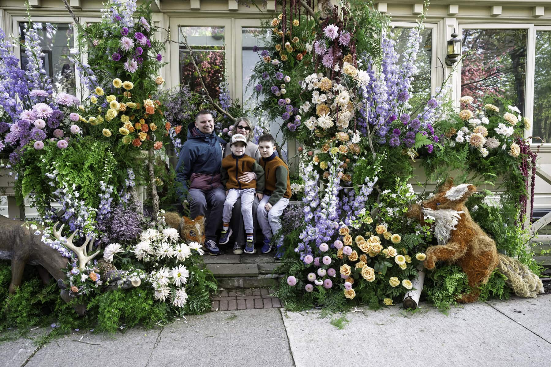 Outside the Drawing Room of the Prince of Wales Hotel, Dmitry and Eugenia Kornyukhov and their sons, Daniel, 8, and Matthew, 5, are embedded in a woodland wonderland of flowers and critters like deers, foxes and squirrels. This display was created by Bloom & Co.