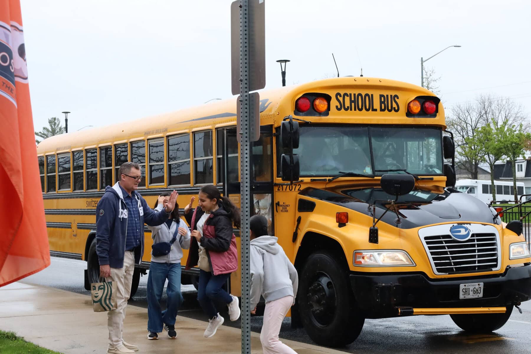 High five! A student and staff member at Crossroads Public School celebrate before a field trip aimed at helping ease the transition tied to the boundary change.