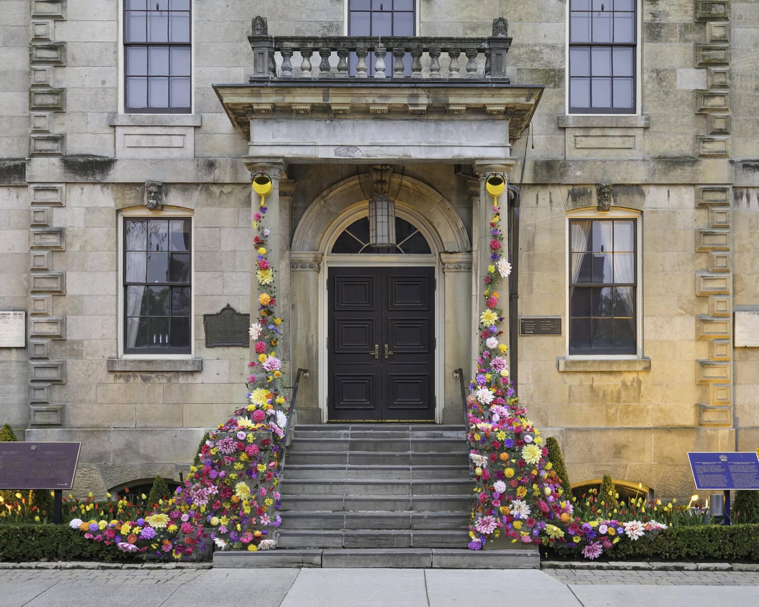 One of Niagara-on-the-Lake's most recognized building, the old Courthouse on Queen Street, with cascading florals draping its facade (note the bright yellow watering cans at the top of the pillars). Fête Events designed this display.