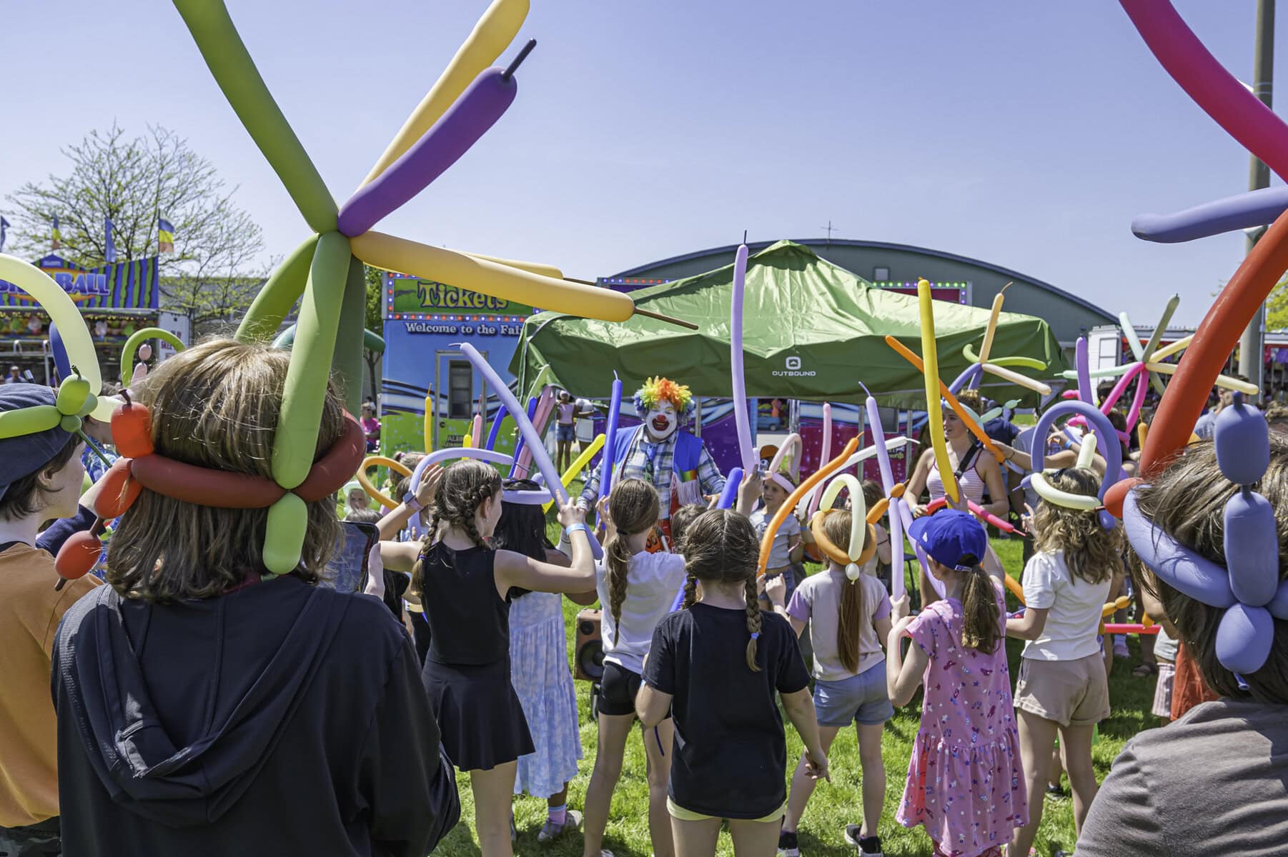 Doo Doo the Clown brings morer whimsy to the fairgrounds, teaching everyone how to create their own balloon crowns.