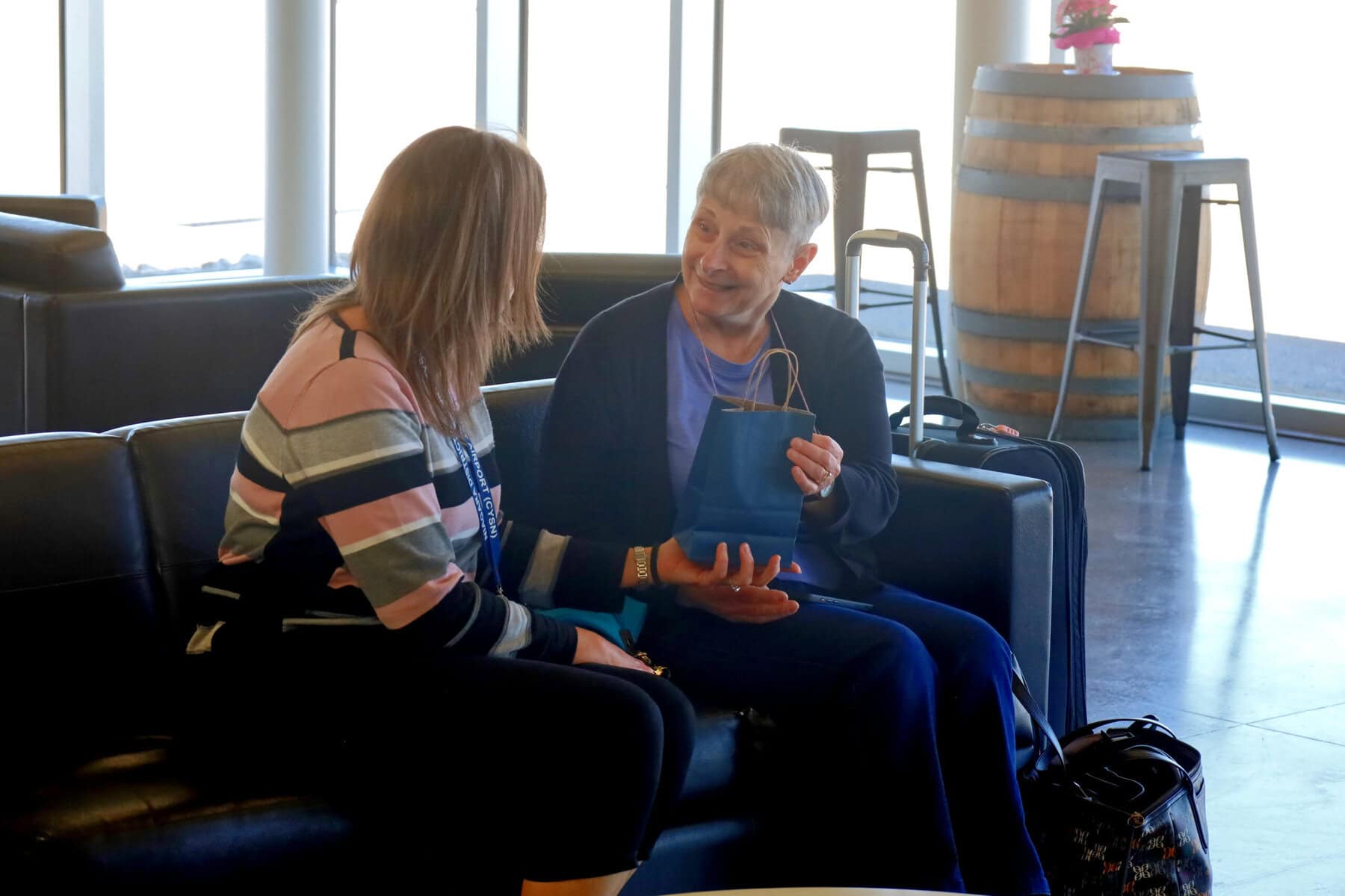 Mary Young, of Fort Erie, receives a welcome gift from administrative assistant Nancy Harris before boarding the Air Canada Landline bus at Niagara District Airport on Monday.