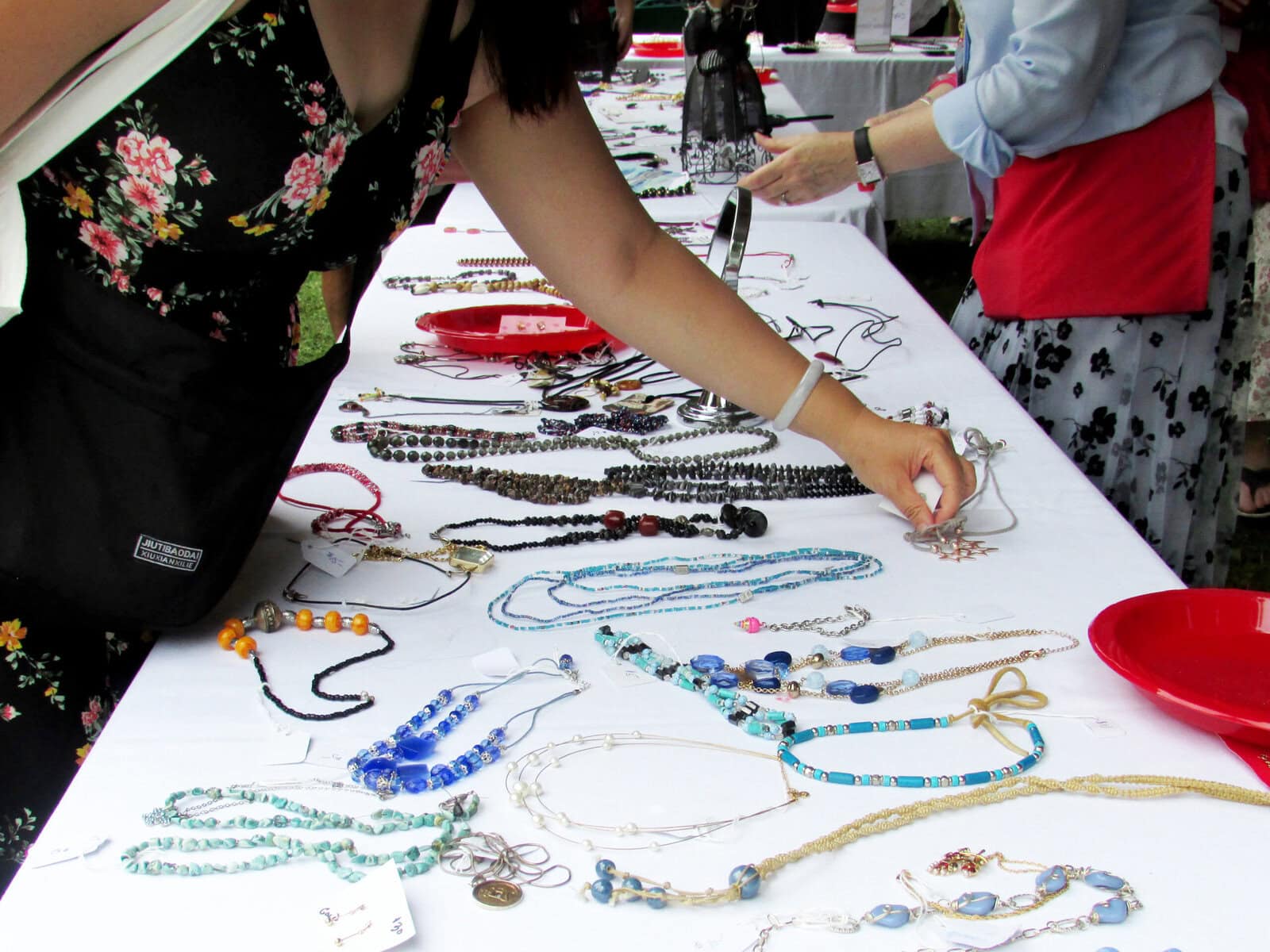 Festivalgoers peruse a table of jewelry for sale by St. Mark's. Proceeds go to keep the more-than-200-year-old church running.