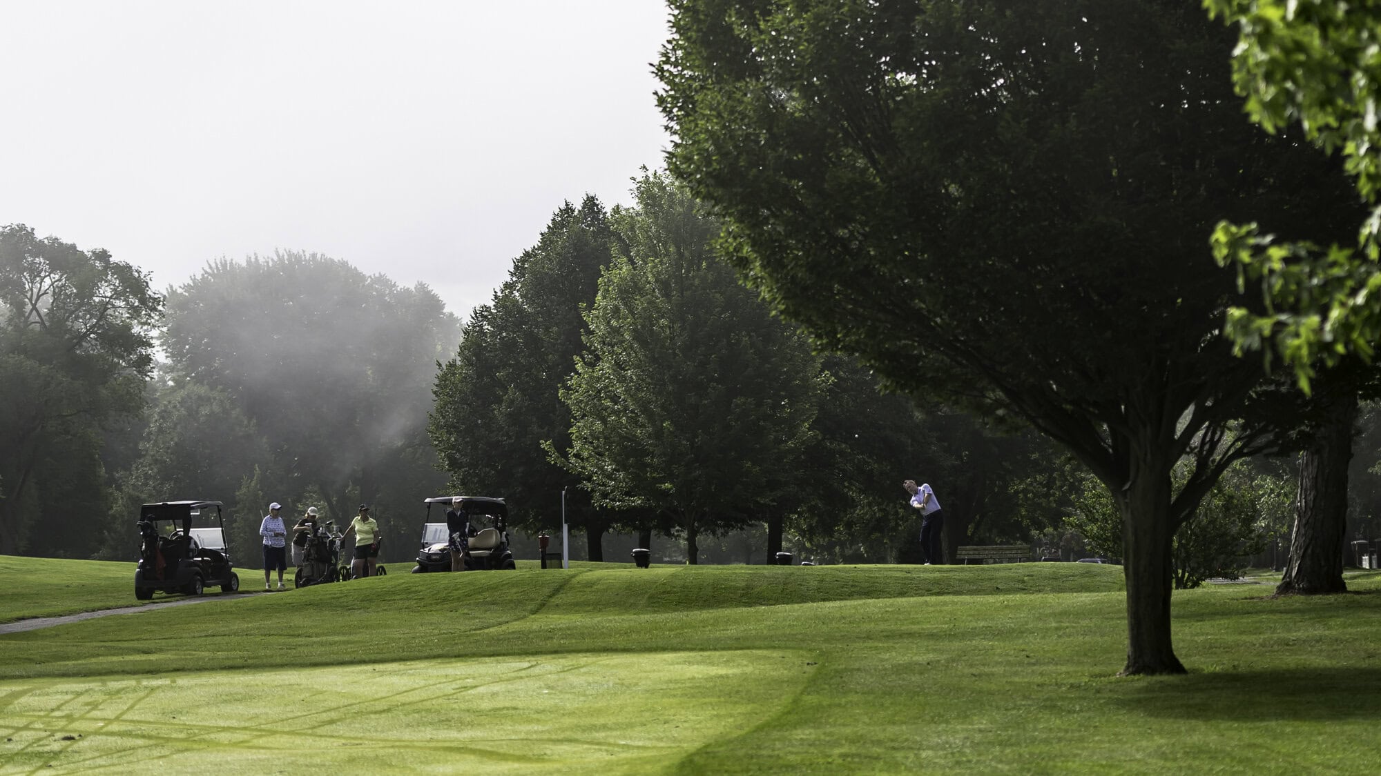 Pro shop manager Darren Smith sends his tee shot toward the fourth green while some of the golfers in the NOTL 18-hole women's league wait for a chance to try to Beat the Pro. 