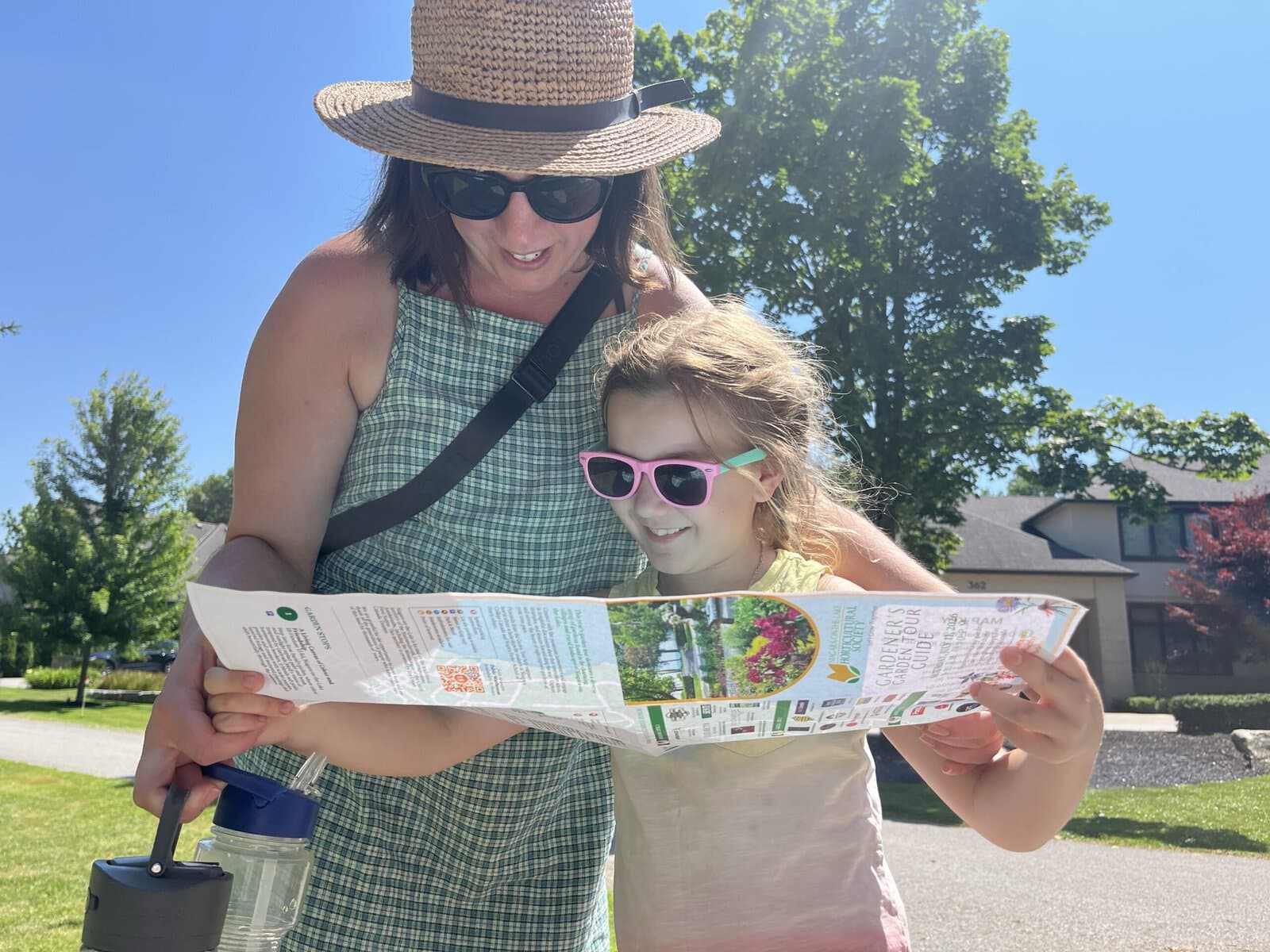 Tiffany Tsantsoulas and her eight-year-old daughter, Lena, decide where to head next on the Gardener’s Garden Tour on Saturday. The tour invited the public to discover local gardeners’ sanctuaries.