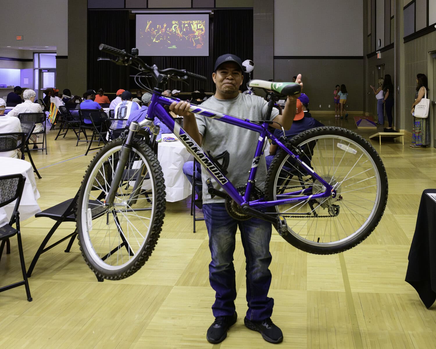 Farmworker Constantino Gonzalez shows off the bike he won during the World Cup viewing event at the NOTL Community Centre on Sunday. 