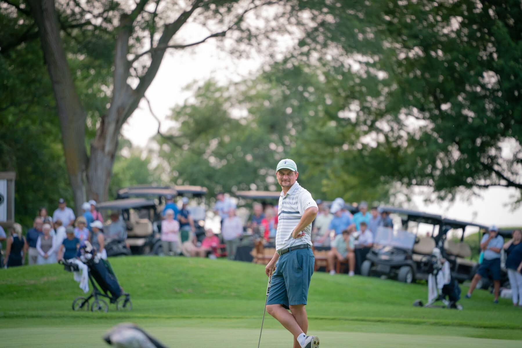 A large gallery looks on as James Grigjanis-Meusel and the final men's group finishes their round Sunday.