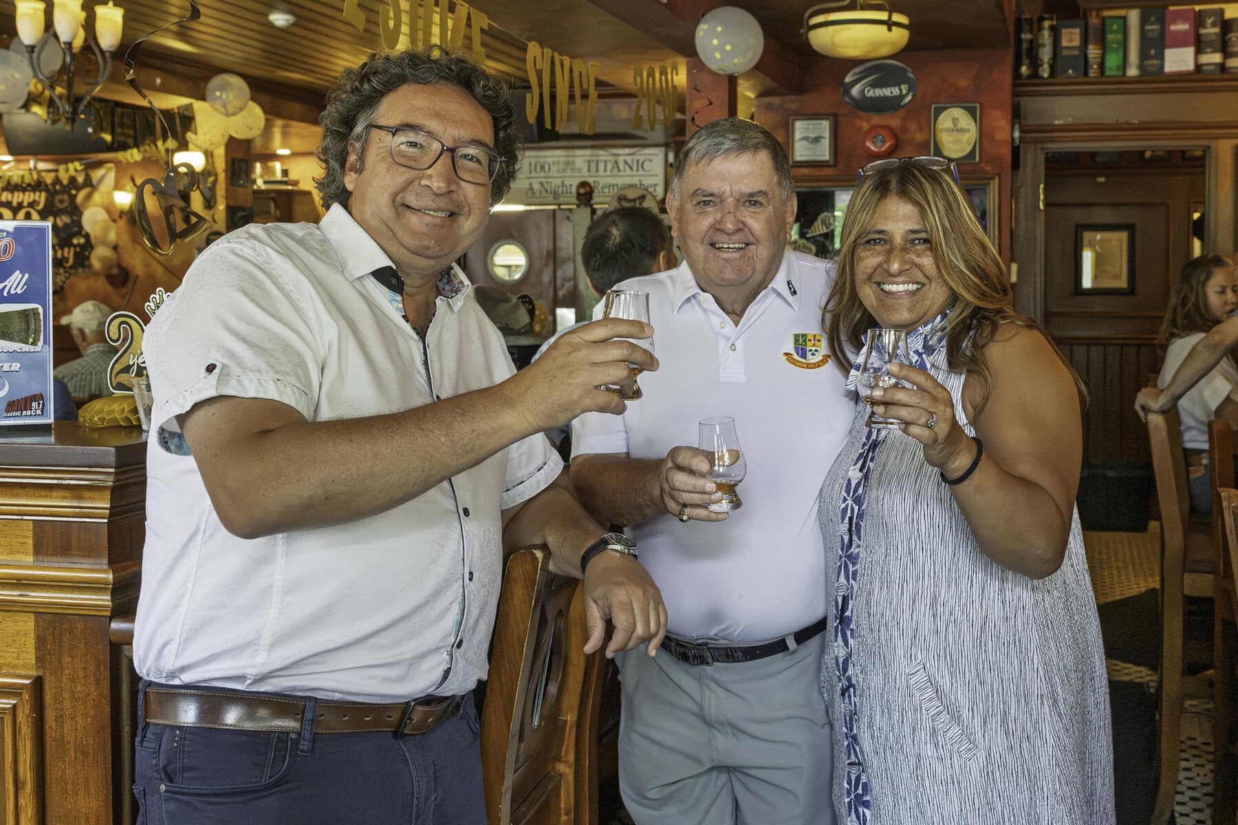 From left, Lord Mayor Gary Zalepa, business owner Ward Simpson and Irish Harp owner Jovie Joki raise their glasses in celebration of the Irish Harp's 20 years in business.