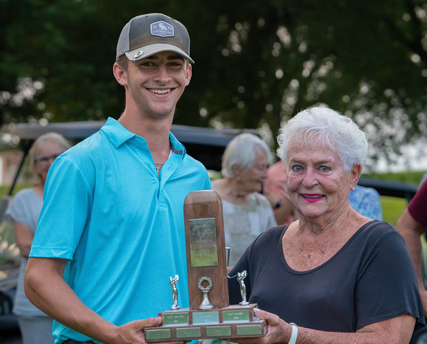 Junior boys champ receives the winners' trophy from Judy Cardiff.